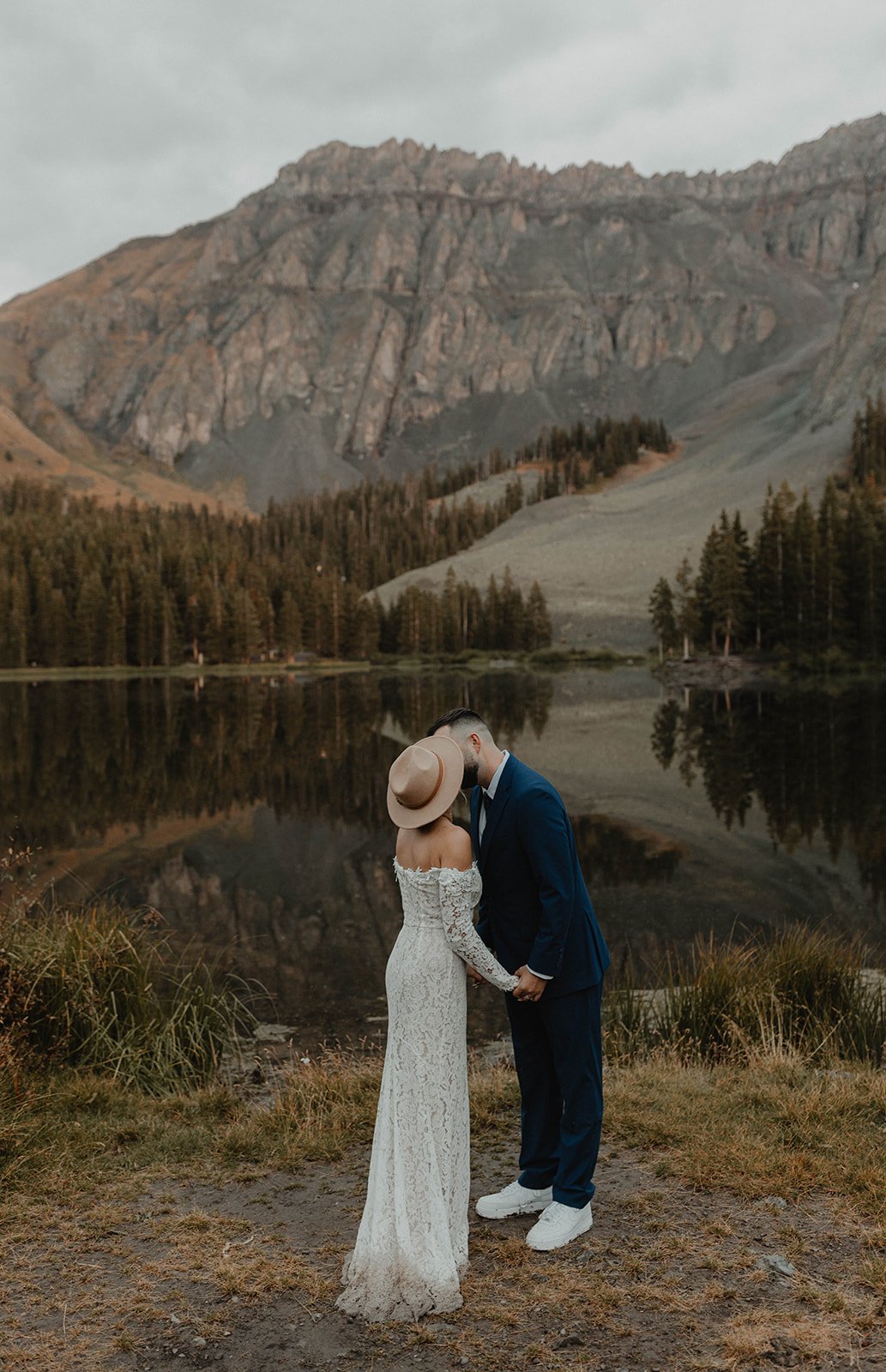 Couple reading handwritten vows beside an alpine lake in the San Juan Mountains