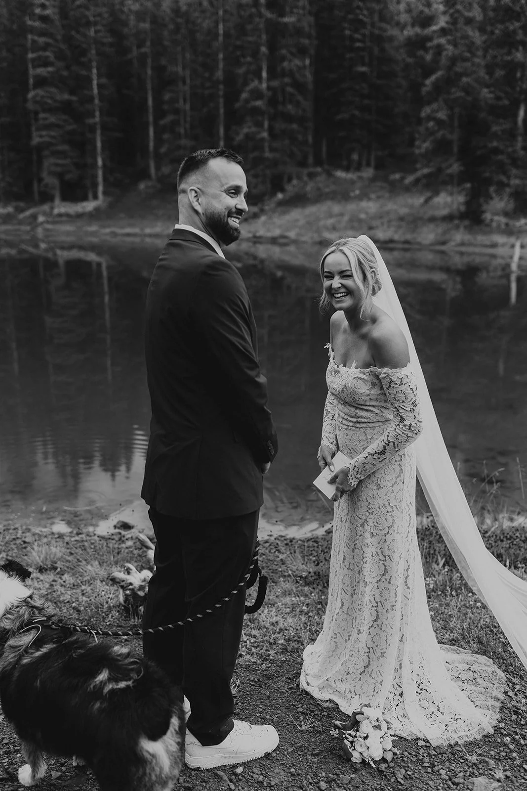 Couple laughing during vows as their dog plays in the mud at Alta Lakes
