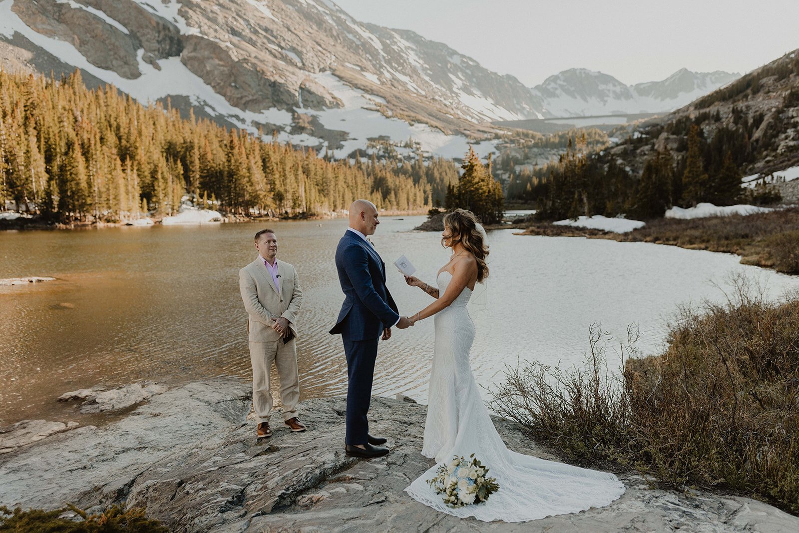 Couple exchanging vows at alpine lake in Breckenridge Colorado at sunset