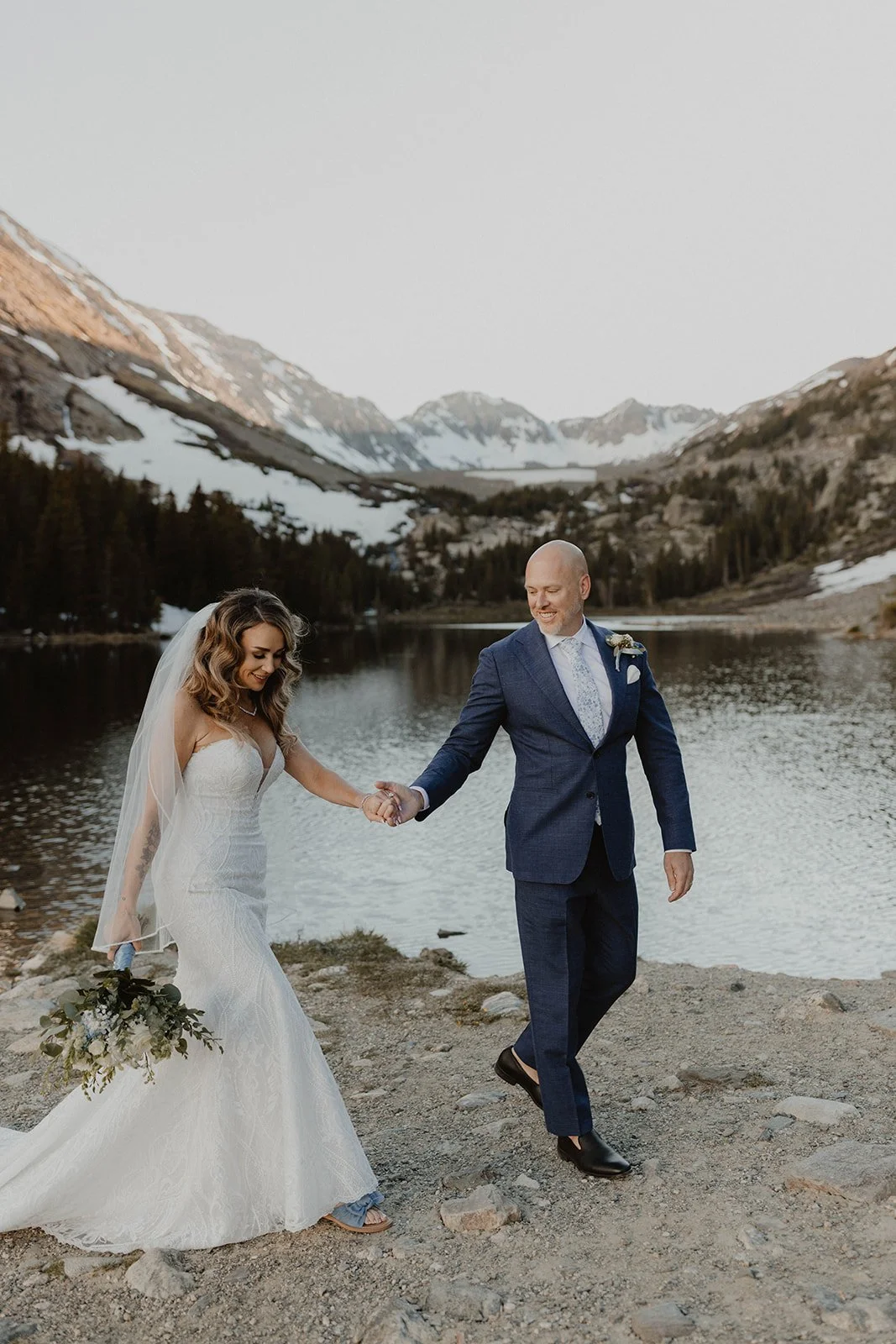 Couple walking along alpine lake in Breckenridge Colorado during golden hour