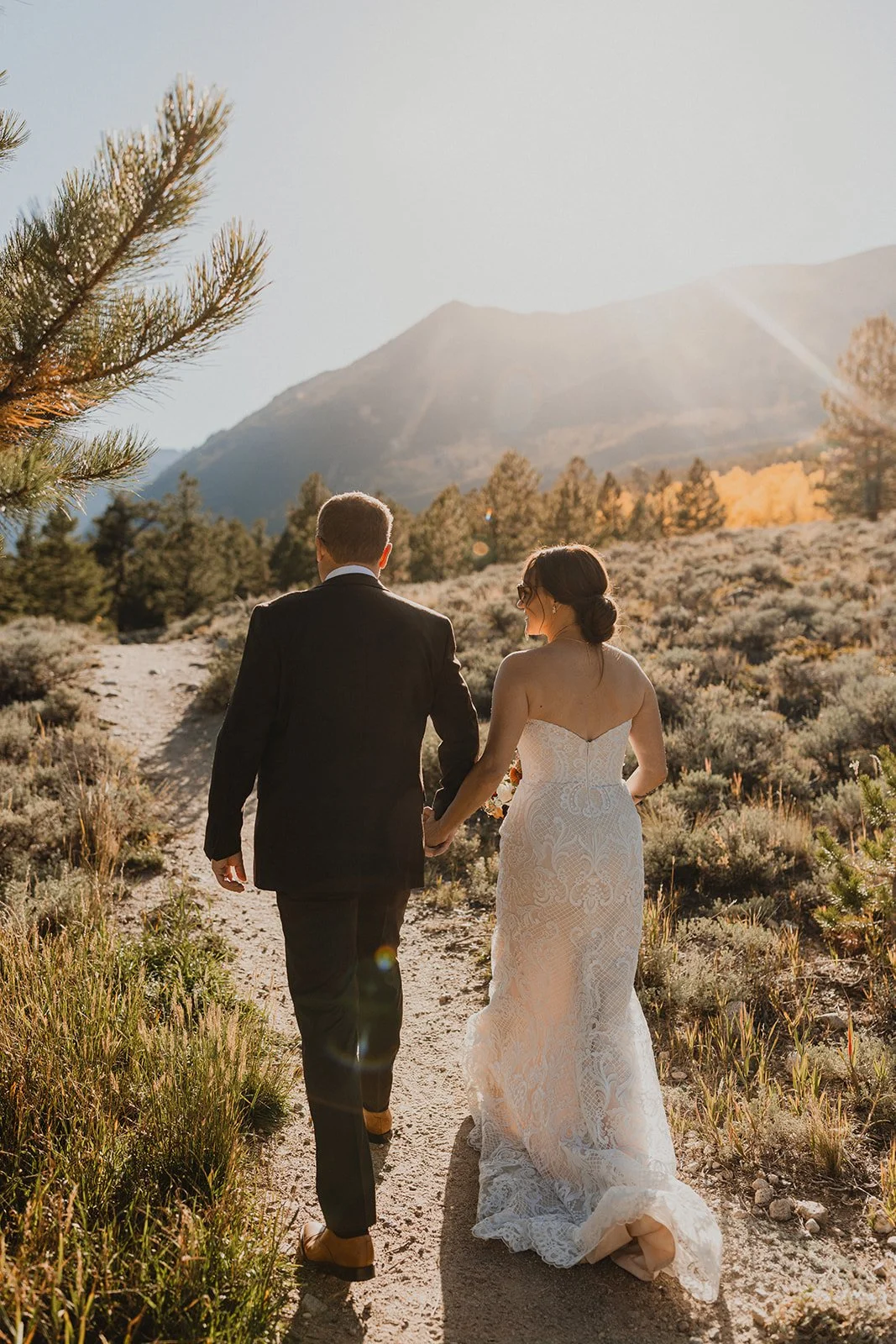 Bride and groom hiking to their ceremony location above Twin Lakes in Buena Vista, Colorado