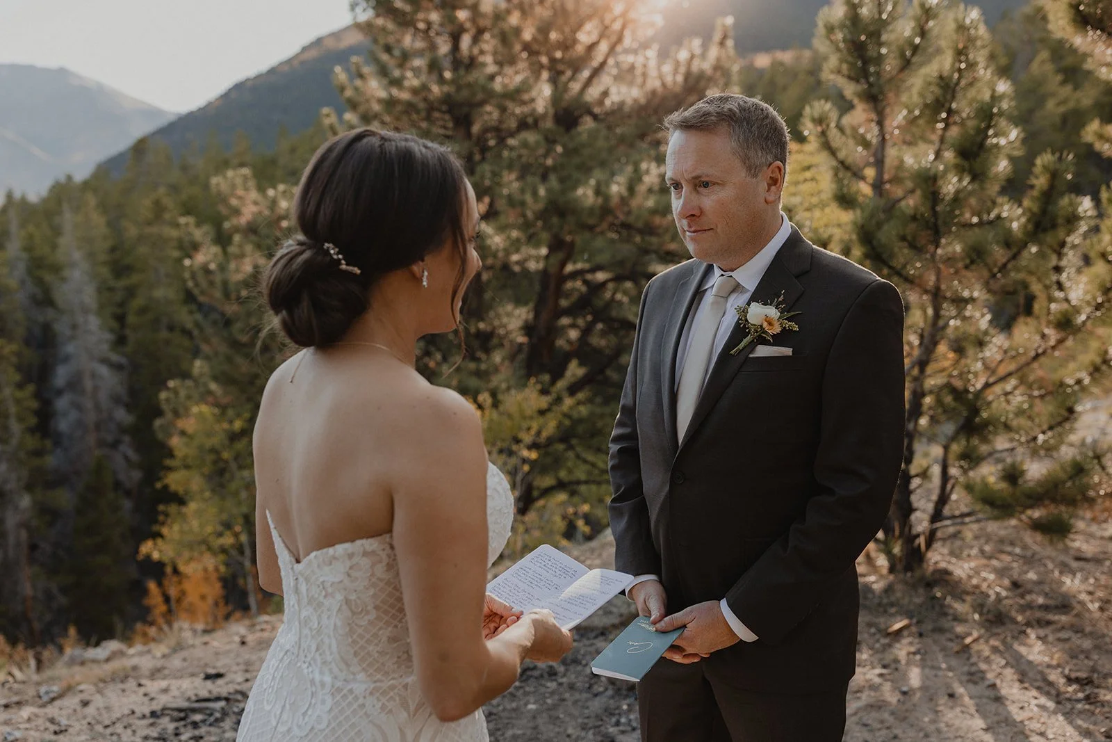 Bride and groom sharing handwritten vows above Twin Lakes in Colorado during fall