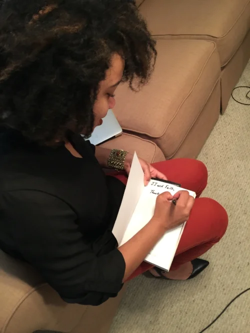 Kielah signs a book for thePlatform314.