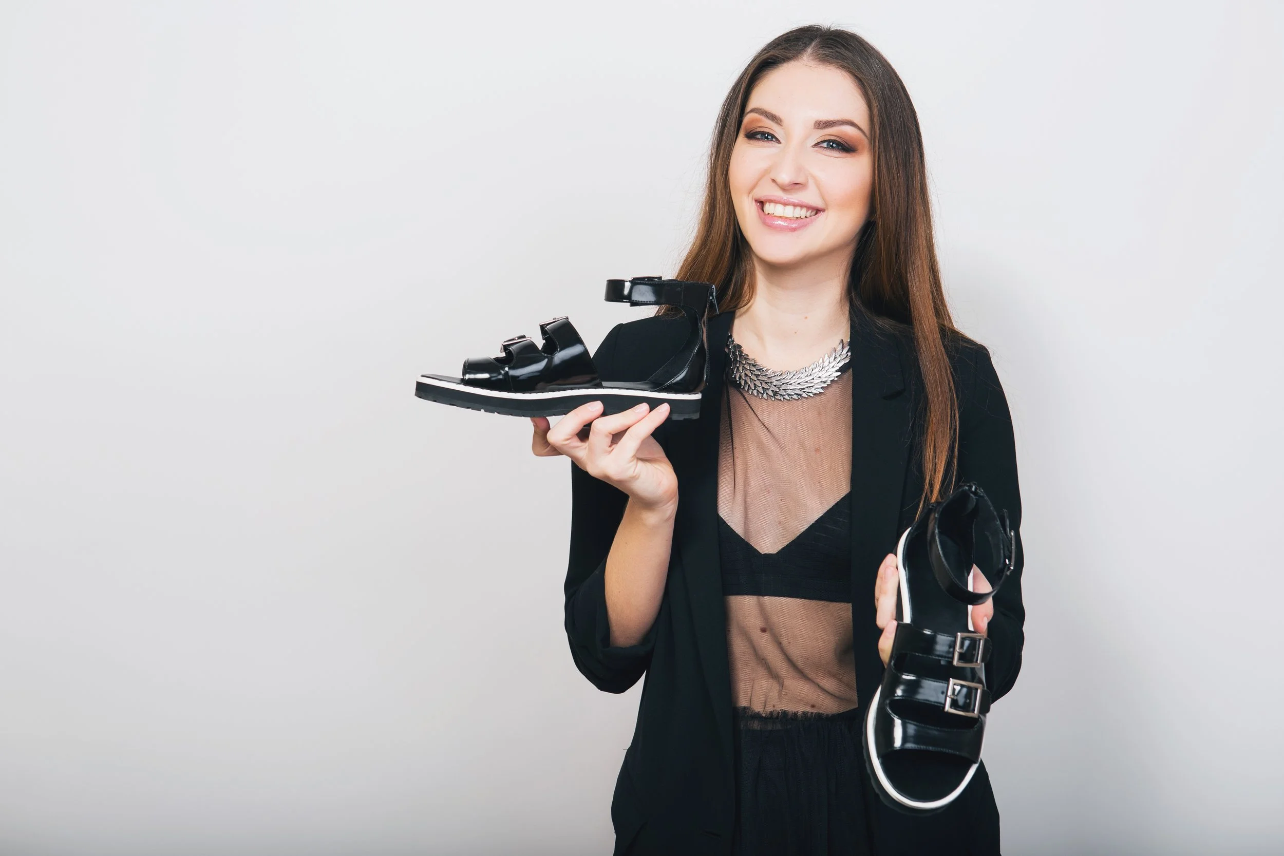 stylish-woman-isolated-black-suit-holding-pait-shoes.jpg