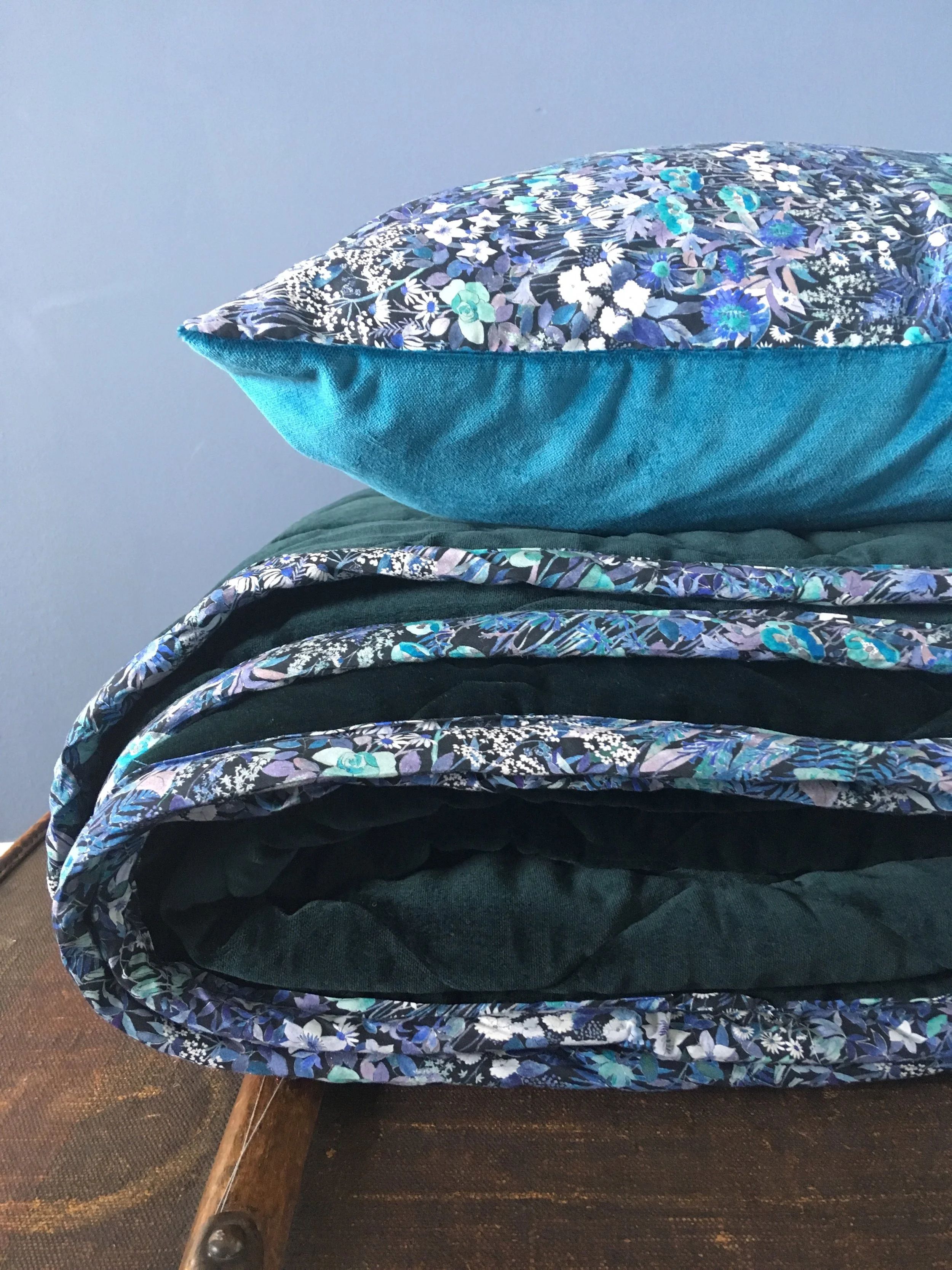 Cushion in Liberty of London ‘Faria Flowers’ with Athenian Blue Velvet. Quilt in ocean green velvet with trim in Liberty of London ‘Faria’s Flowers. Available in Double and King Size or by custom order.