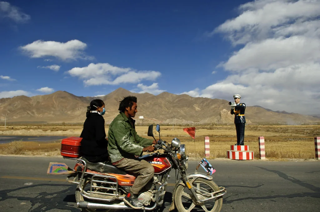 (191) driving a motorcycle by a plastic policeman, tibet, china.jpg