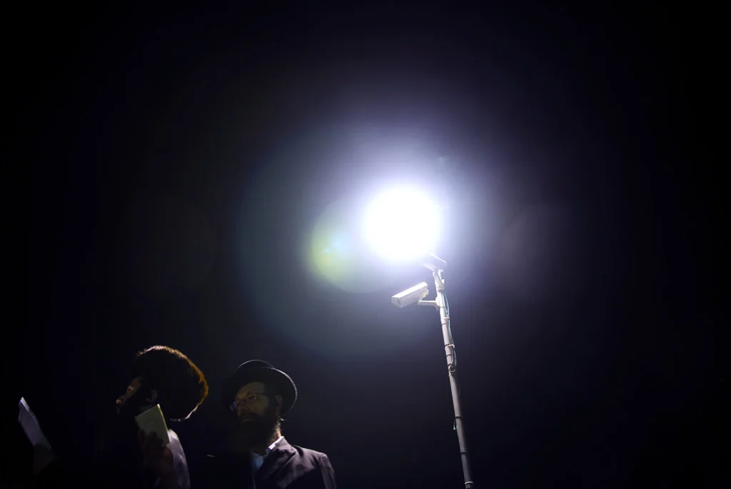 (165) two orthodox jews praying under a light, meron mt, israel.jpg