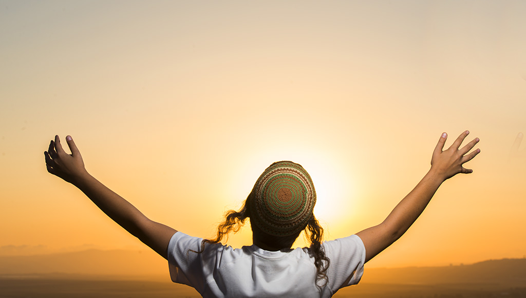 (ts1197) a religious boy raising arms wide at sunset.jpg
