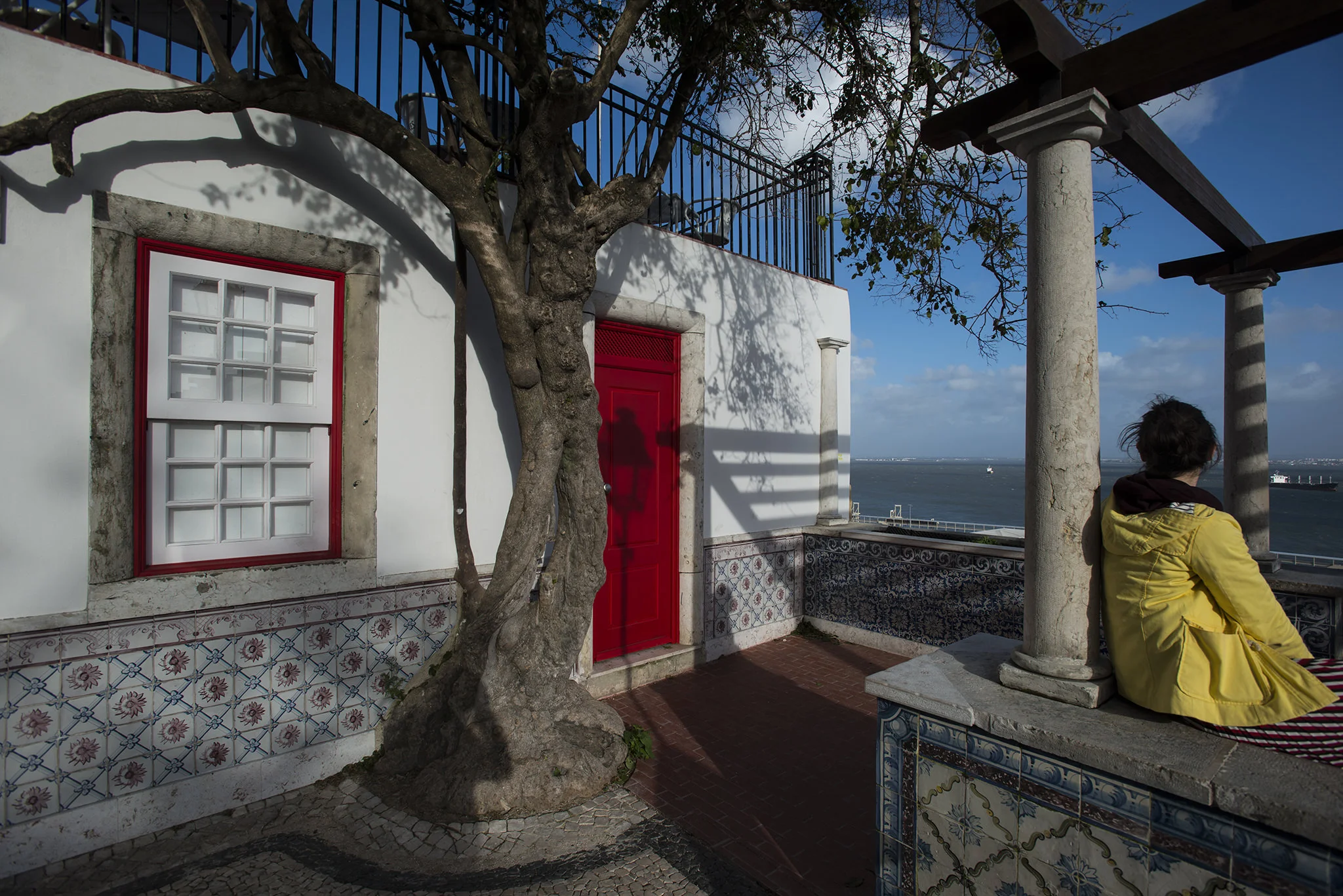 (243) woman with yellow jacket looking at lisbon.jpg
