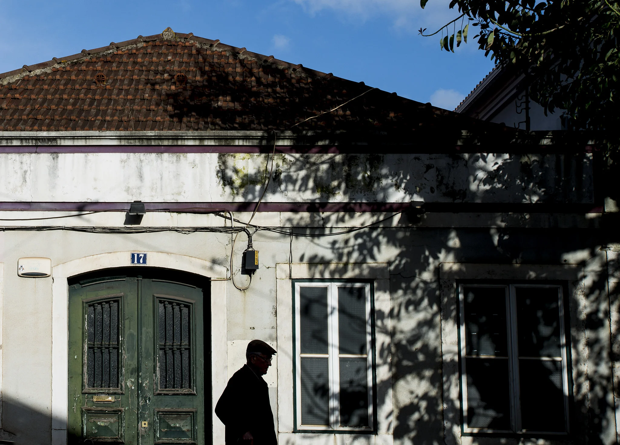 man passes by a house, lisbon.jpg