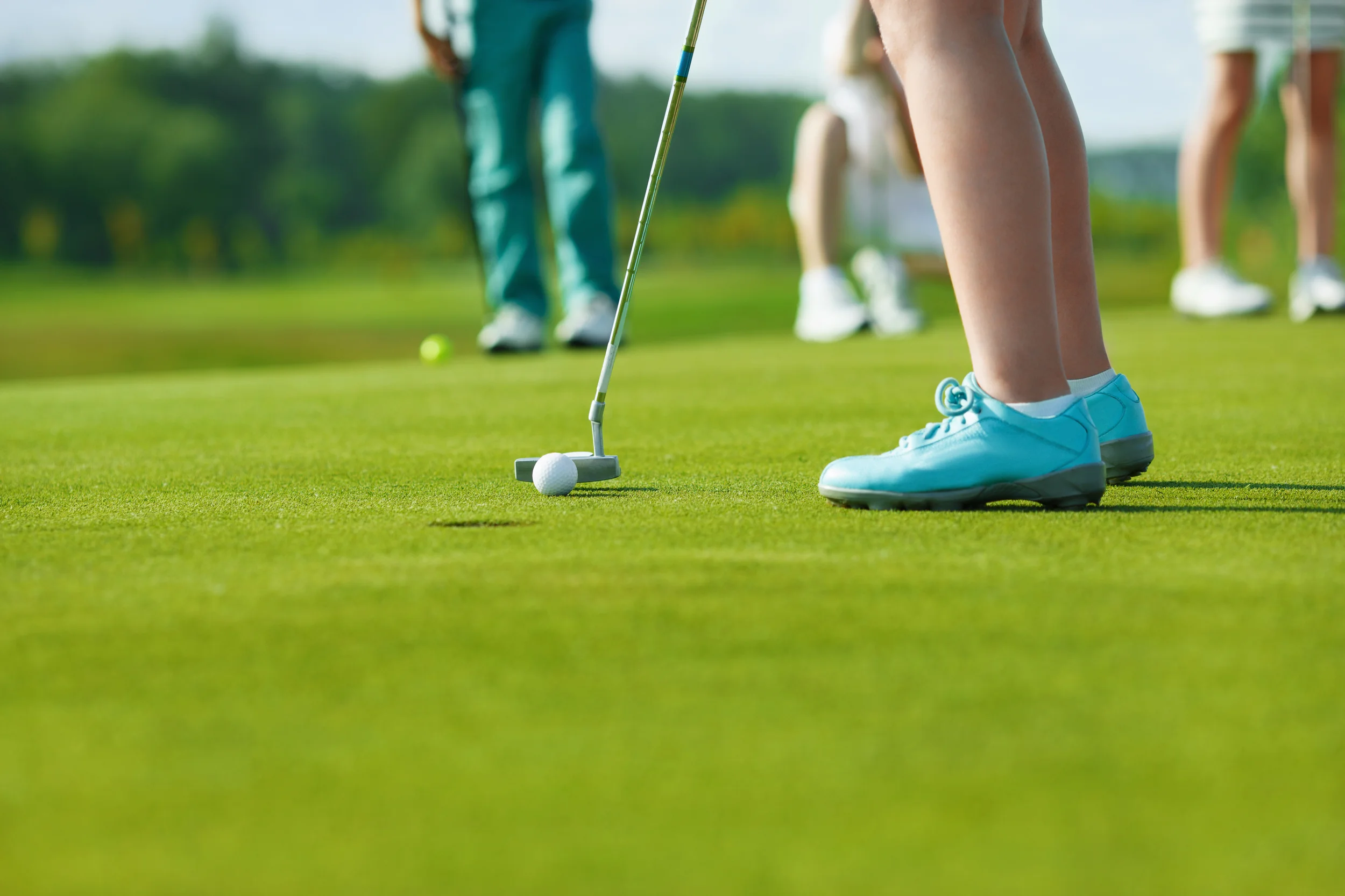 Junior girl at Limitless Golf putting in the hole