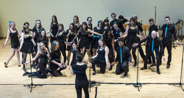 The starling singers hold a pose while emily offers direction