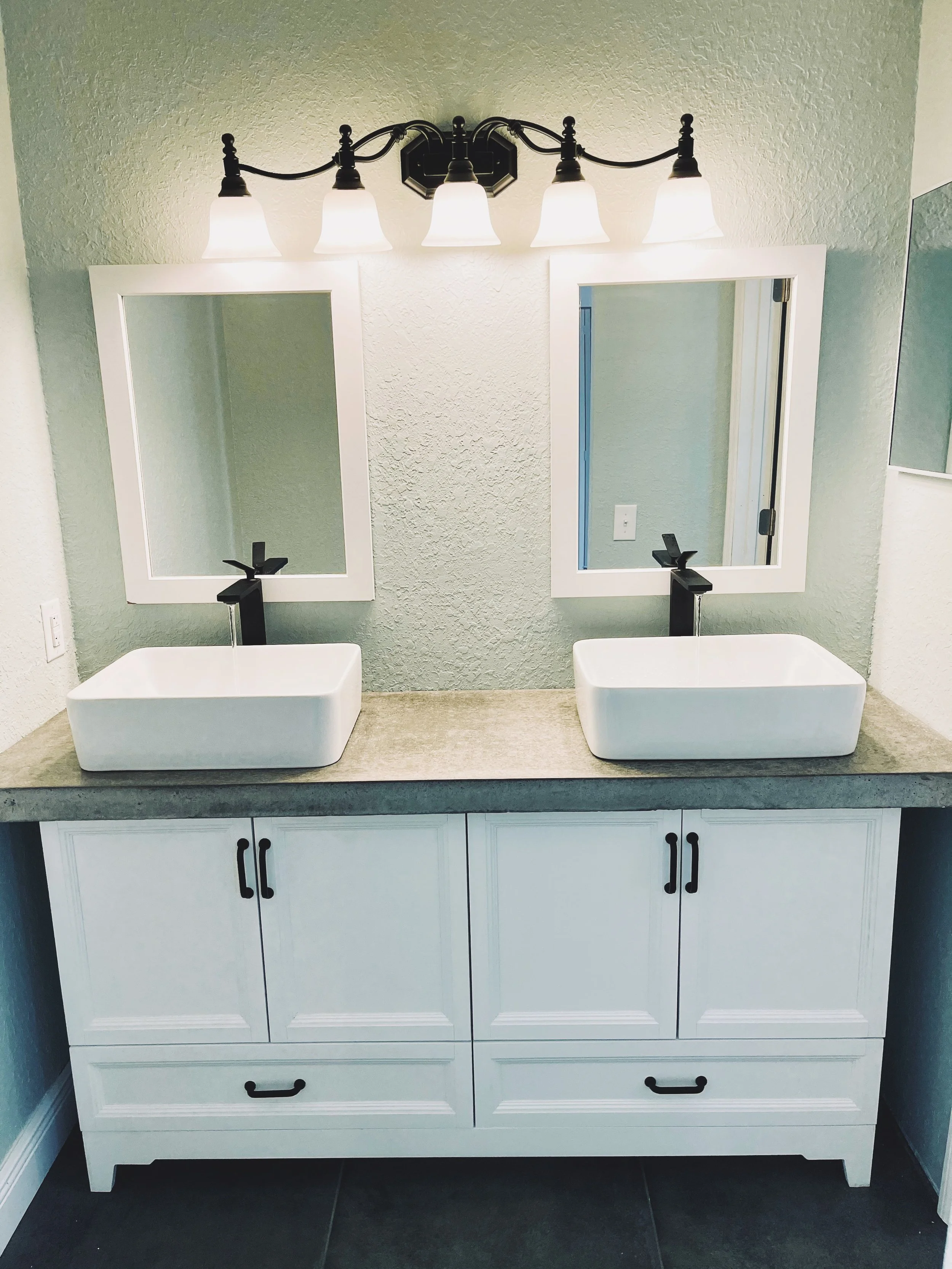 Bathroom concrete countertop and custom installation dual sinks farmhouse style.