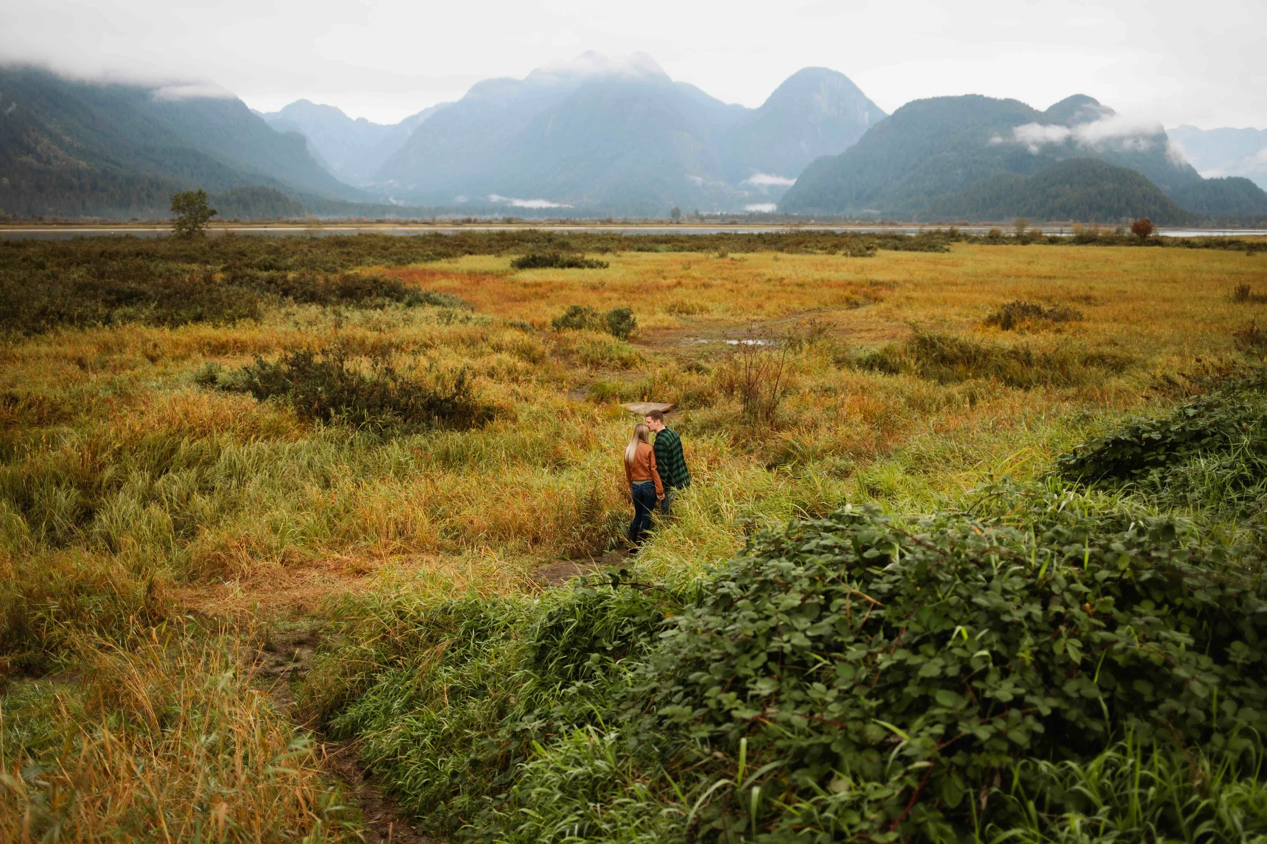Vancouver couple kisses amidst stunning Pitt Lake mountain scenery
