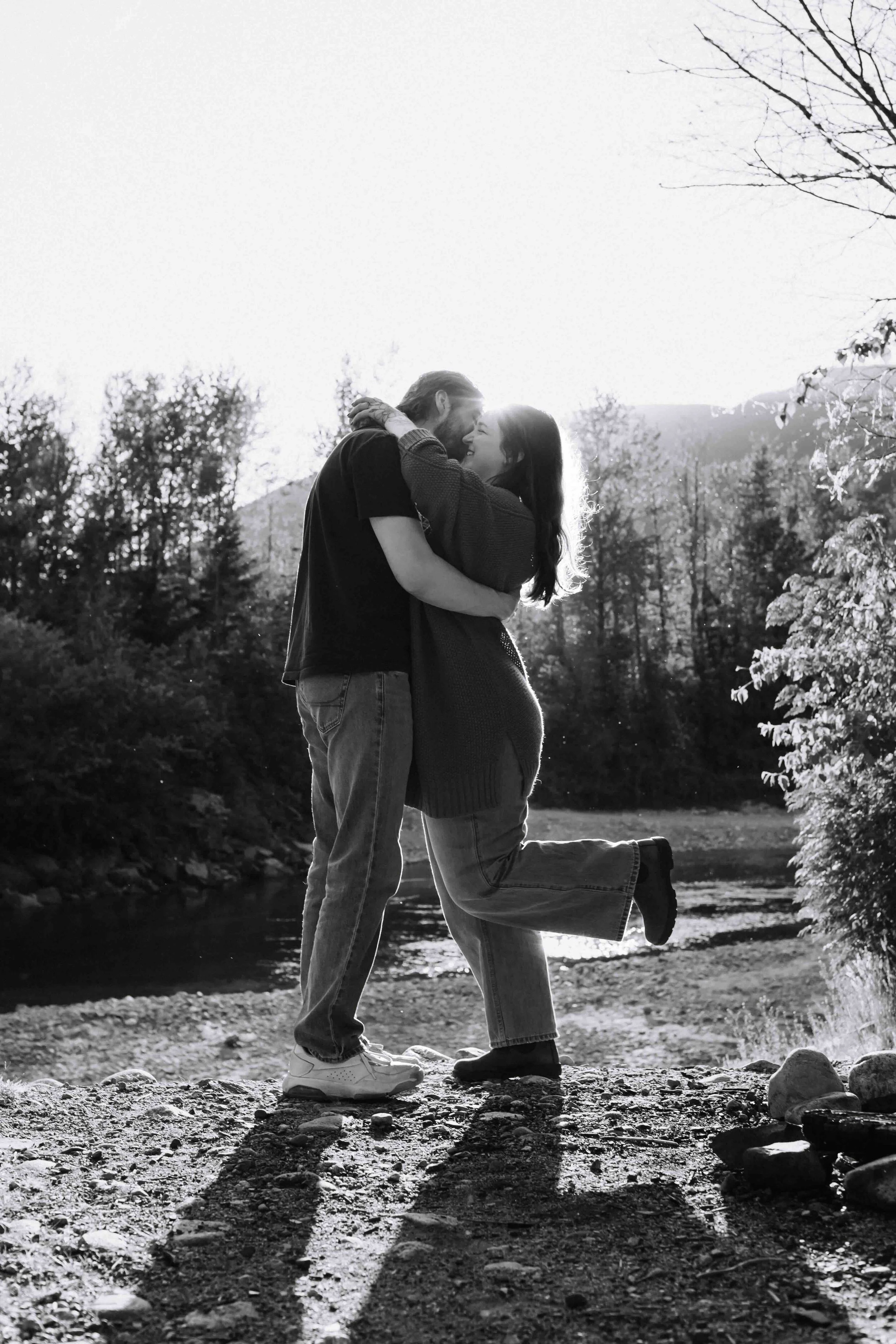 Vancouver man romantically kisses fiancee, who pops her heel in front of a stunning golden hour PNW mountain background