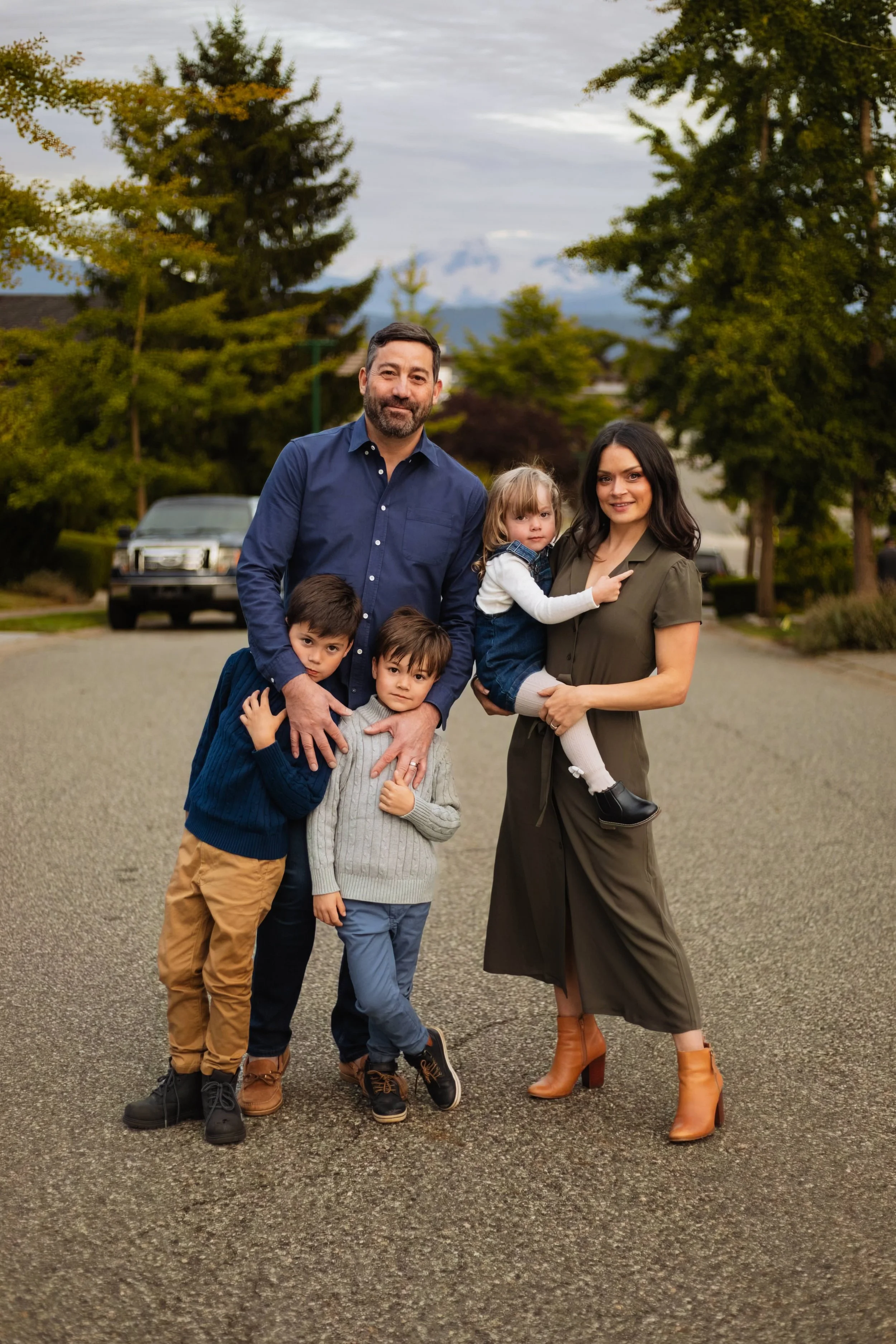 Vancouver family with young kids smiles on road with mountain background