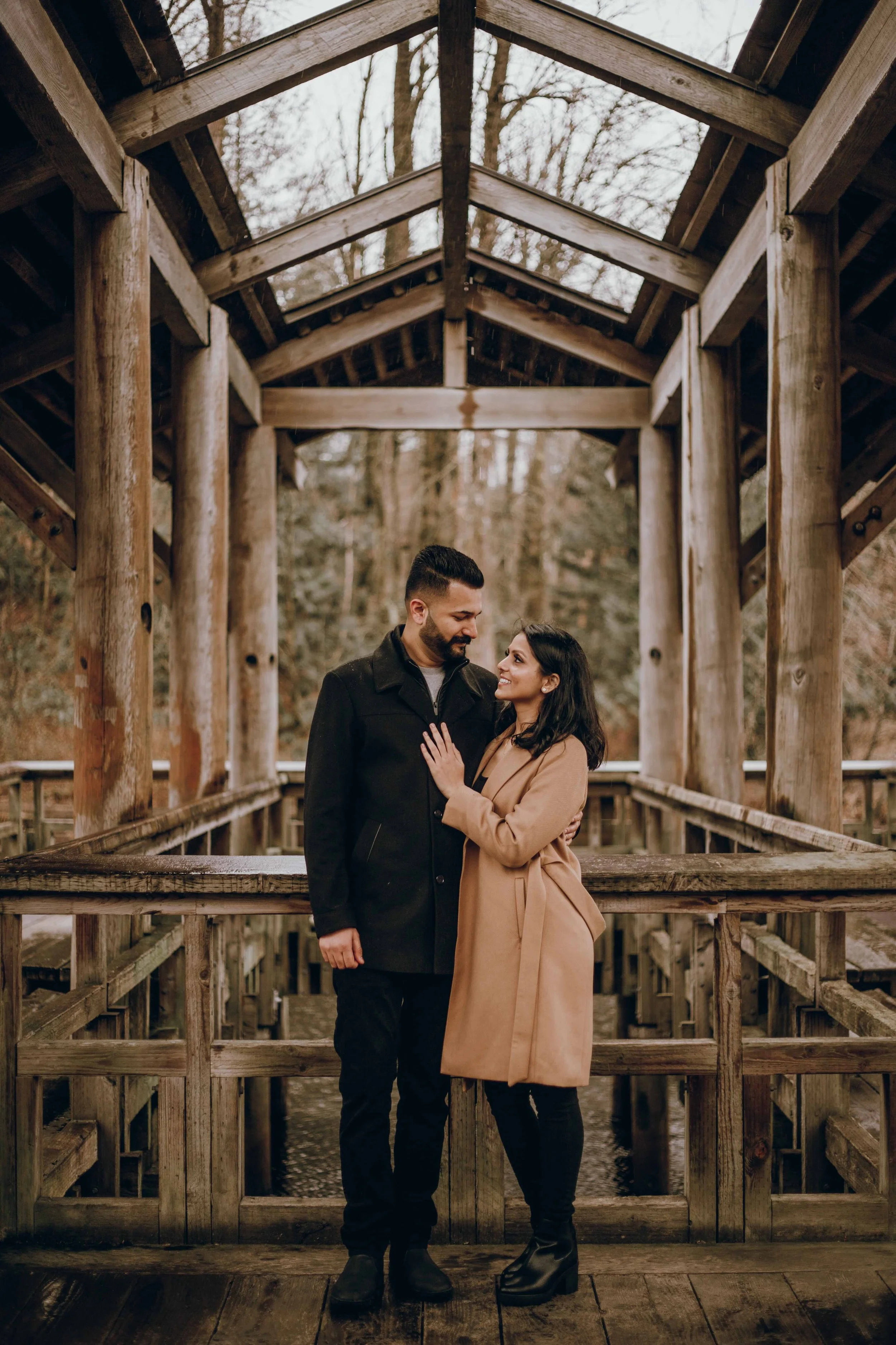 A Vancouver couple under a wooden gazebo at Fish Trap Creek Park, a perfect rainy day photo location in the Fraser Valley.