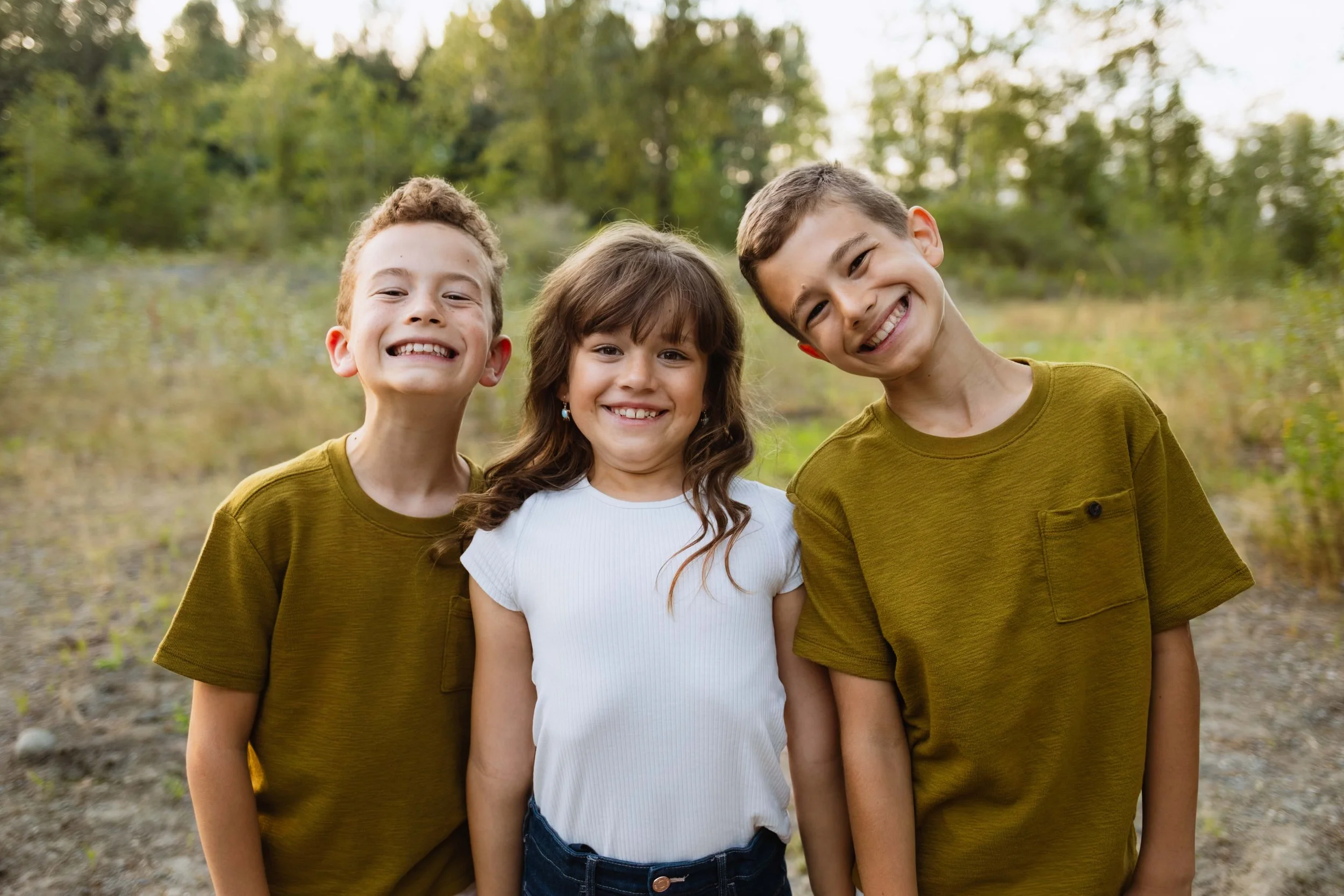 Young Vancouver siblings smile in forest clearing by the Vedder River