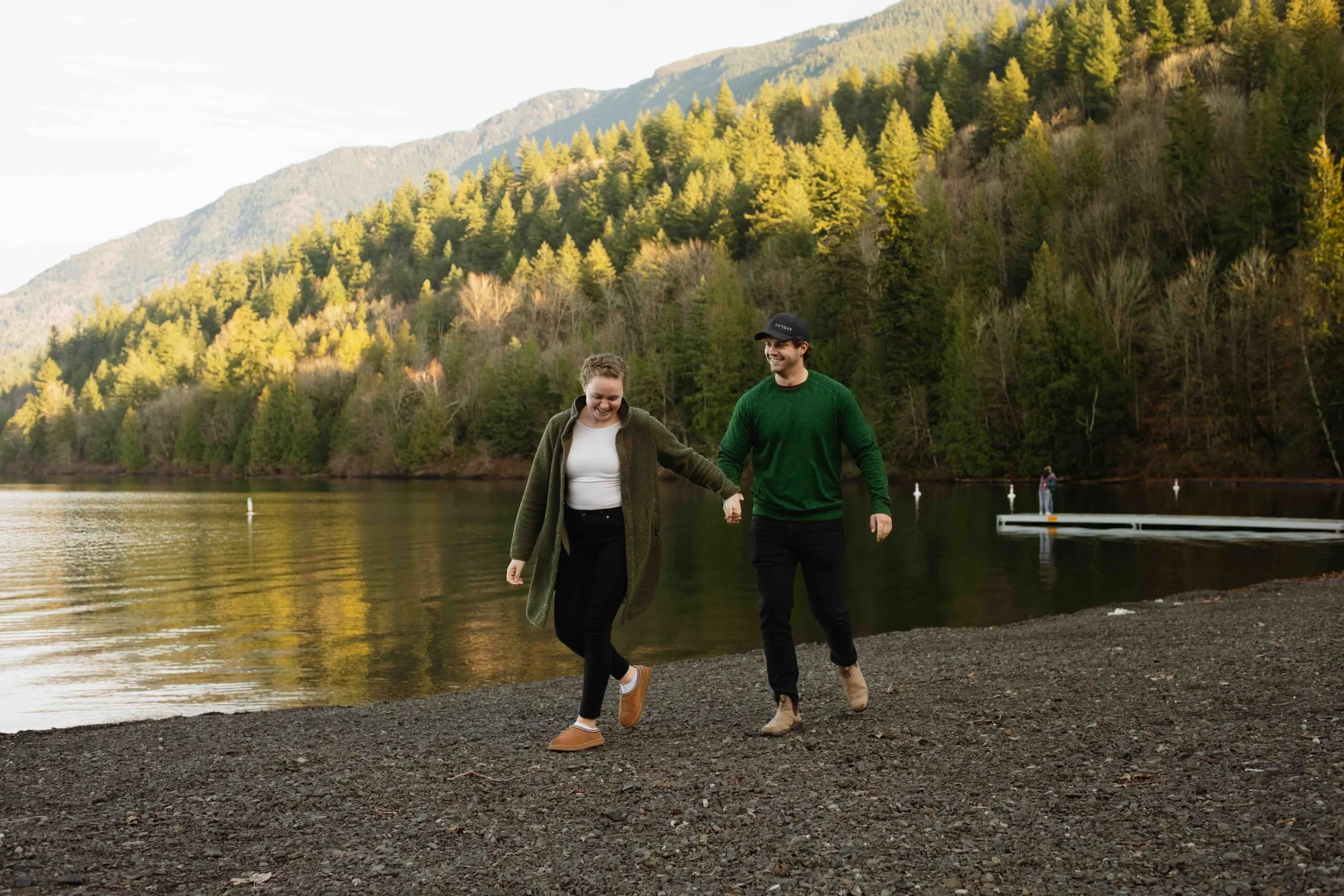 Fun Vancouver couple smiling and holding hands while out for a stroll at Cultus Lake