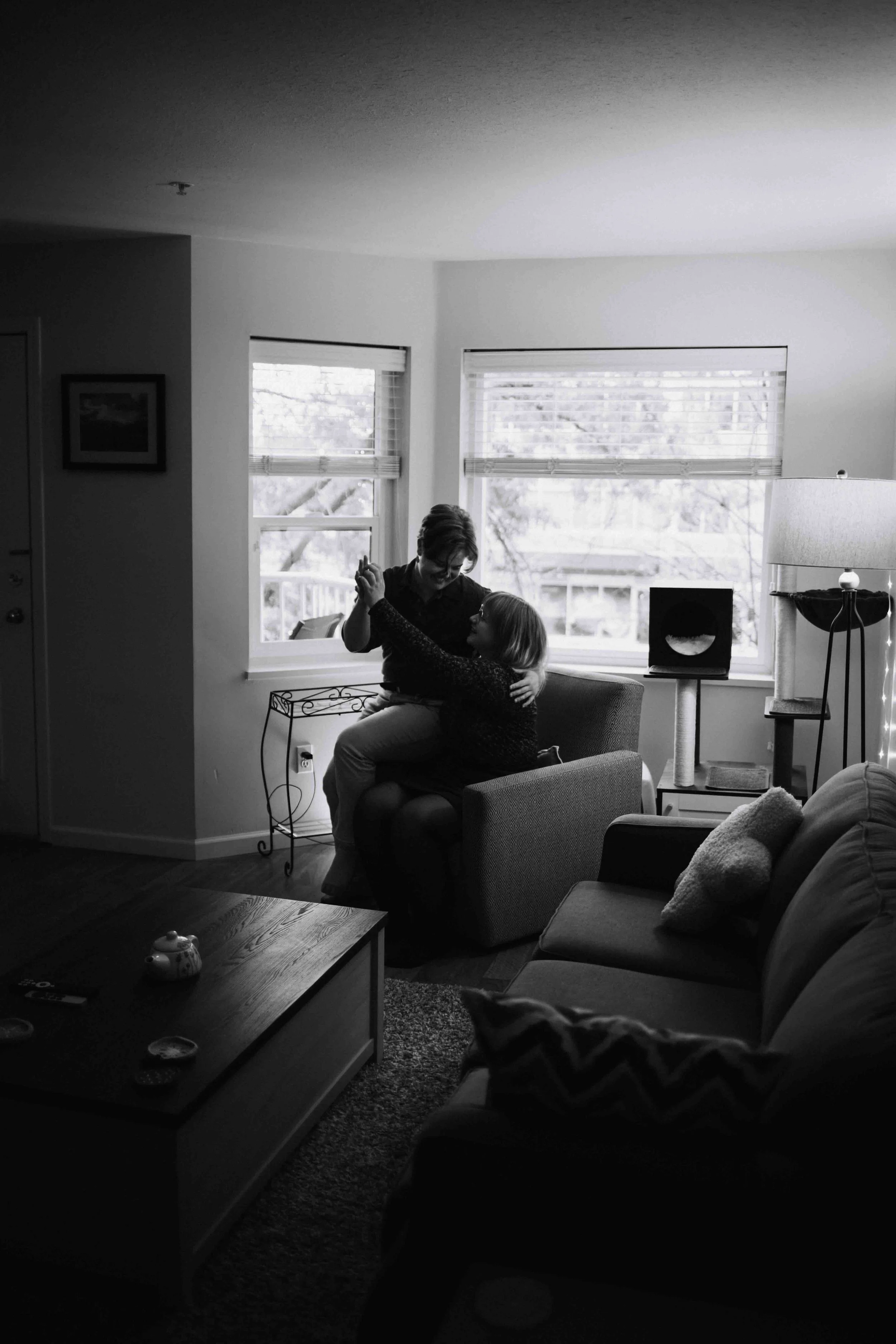 Elegant queer Vancouver couple silhouetted in their cozy living room