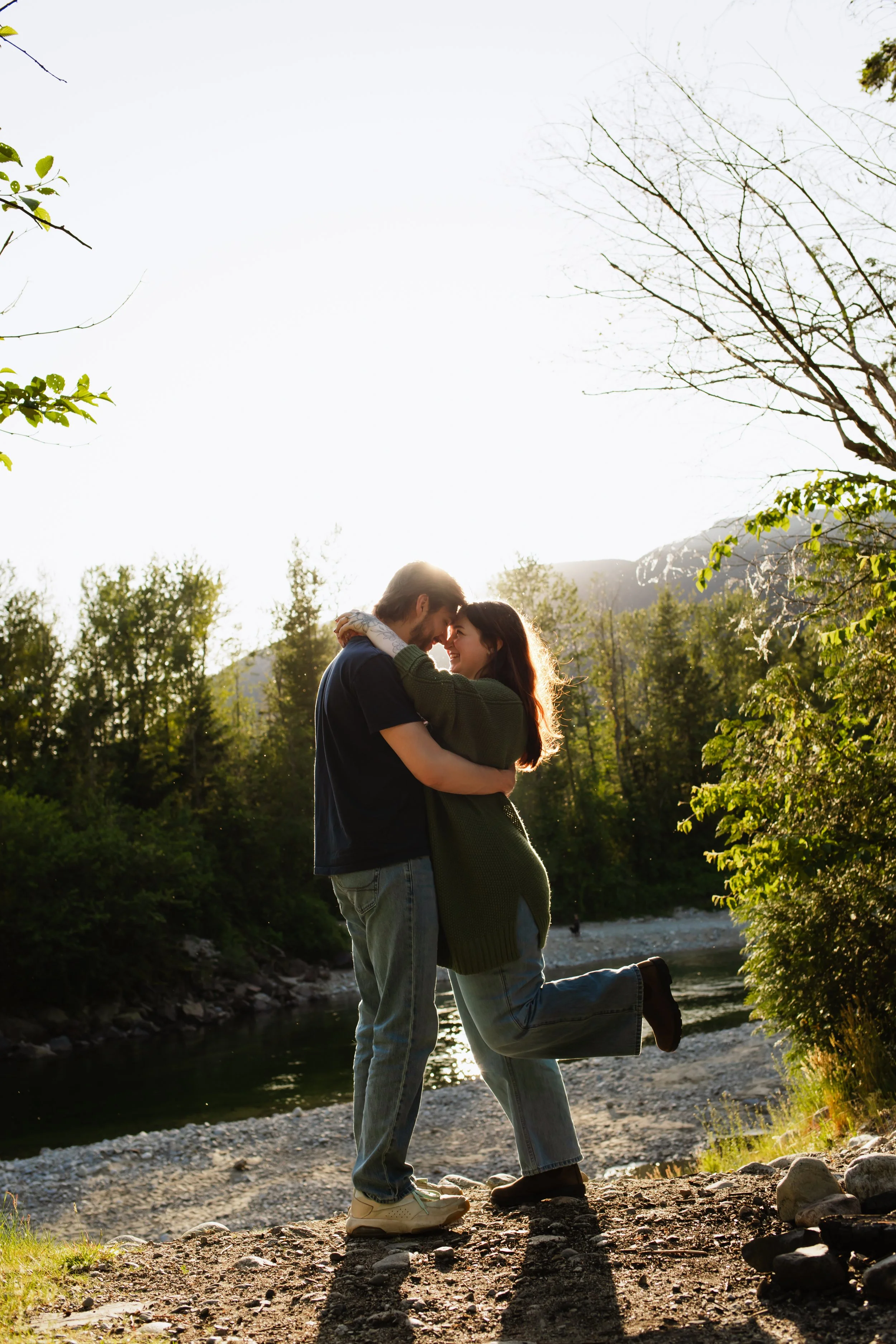 Vancouver couple romantically kisses as sun sets behind Fraser Valley mountains