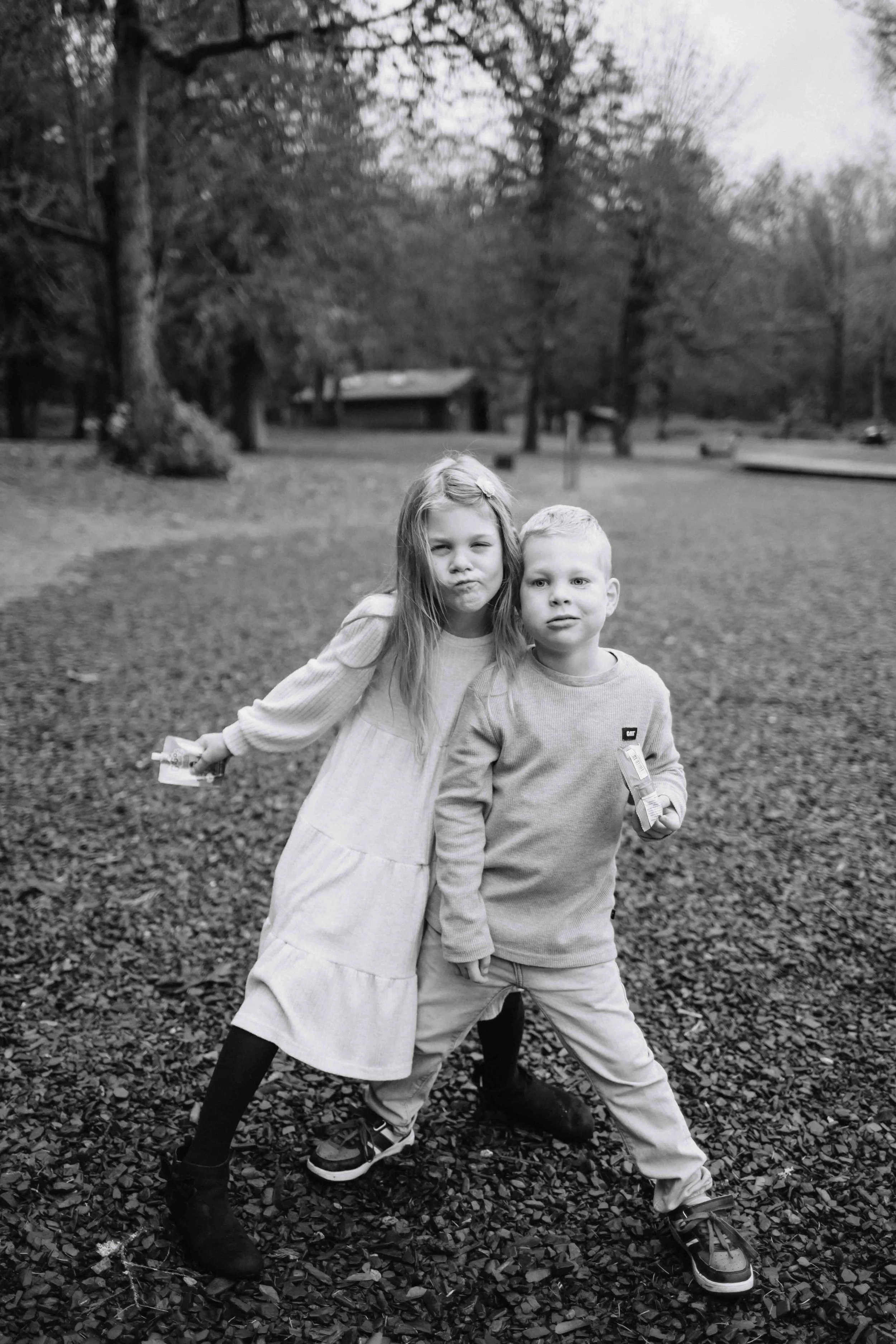 Young kids pose and make funny face while eating snack outdoor camping
