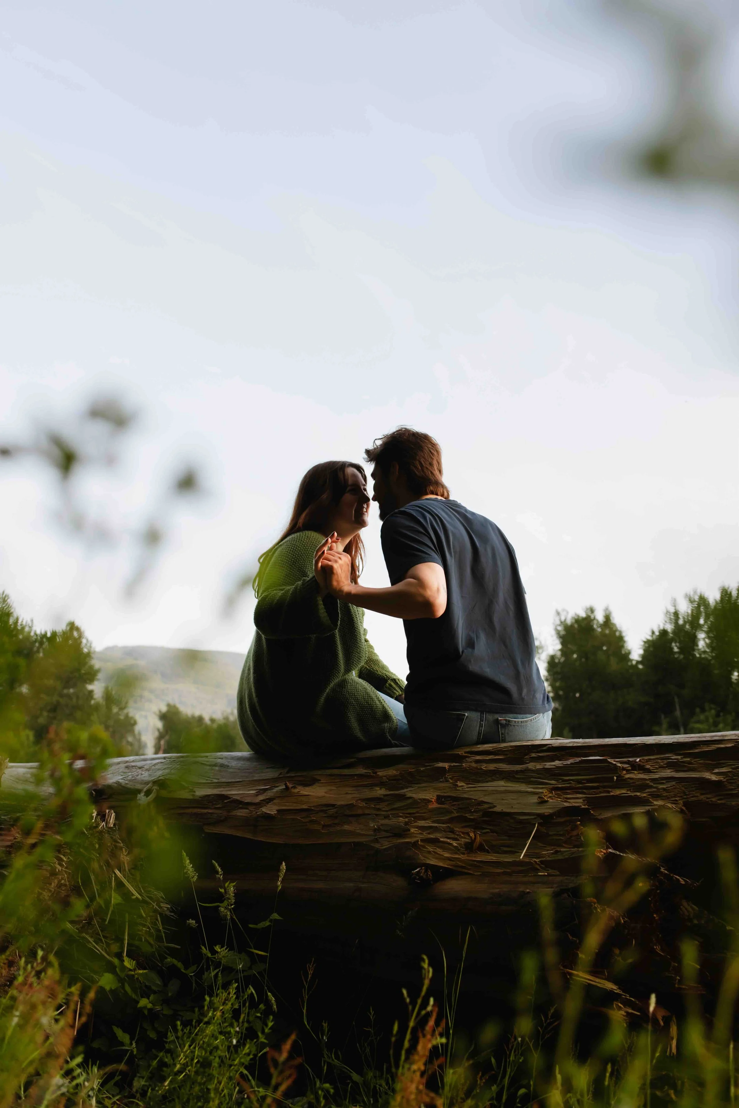 Vancouver couple sits on log and hold hands for a cute photo