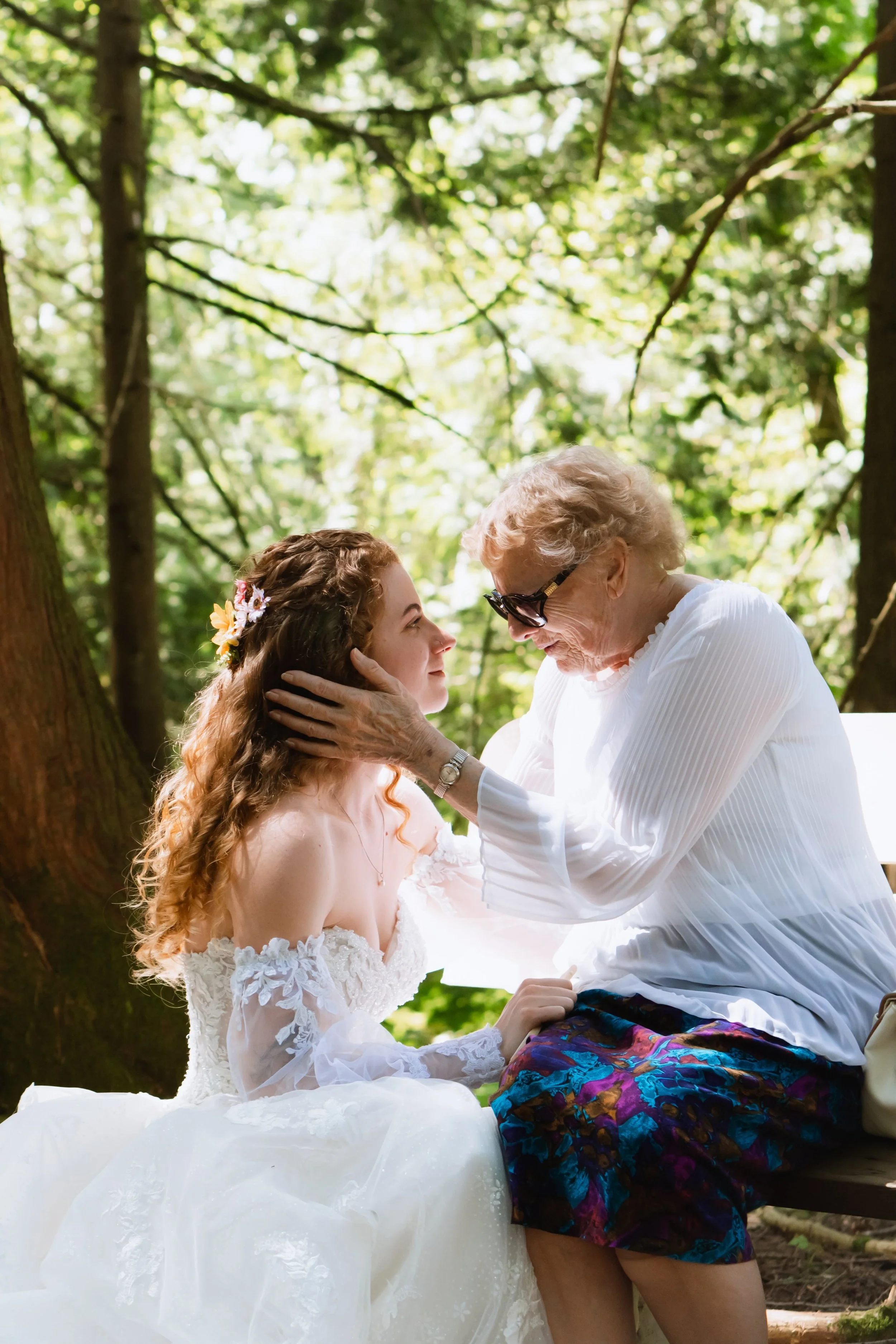 Grandmother gently caresses Vancouver bride's face during tender wedding day moment.