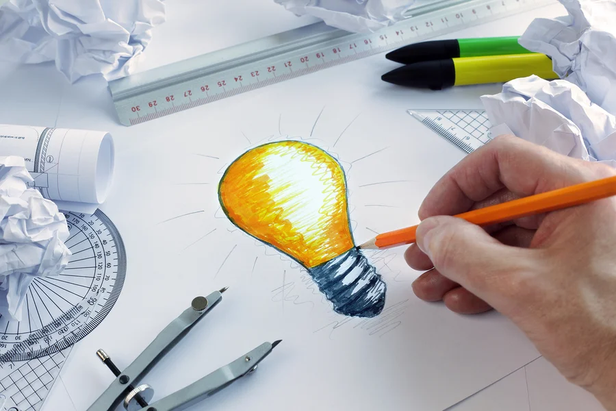bigstock-Designer-drawing-a-light-bulb-59047460.jpg
