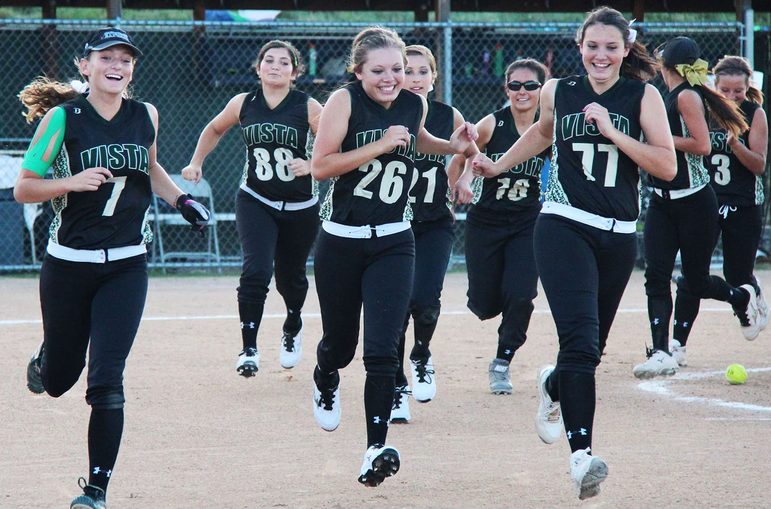 Senior Sarah Lang and junior Hayden Smith lead their team to the fence after defeating ThunderRidge High School in extra innings, 8-7.