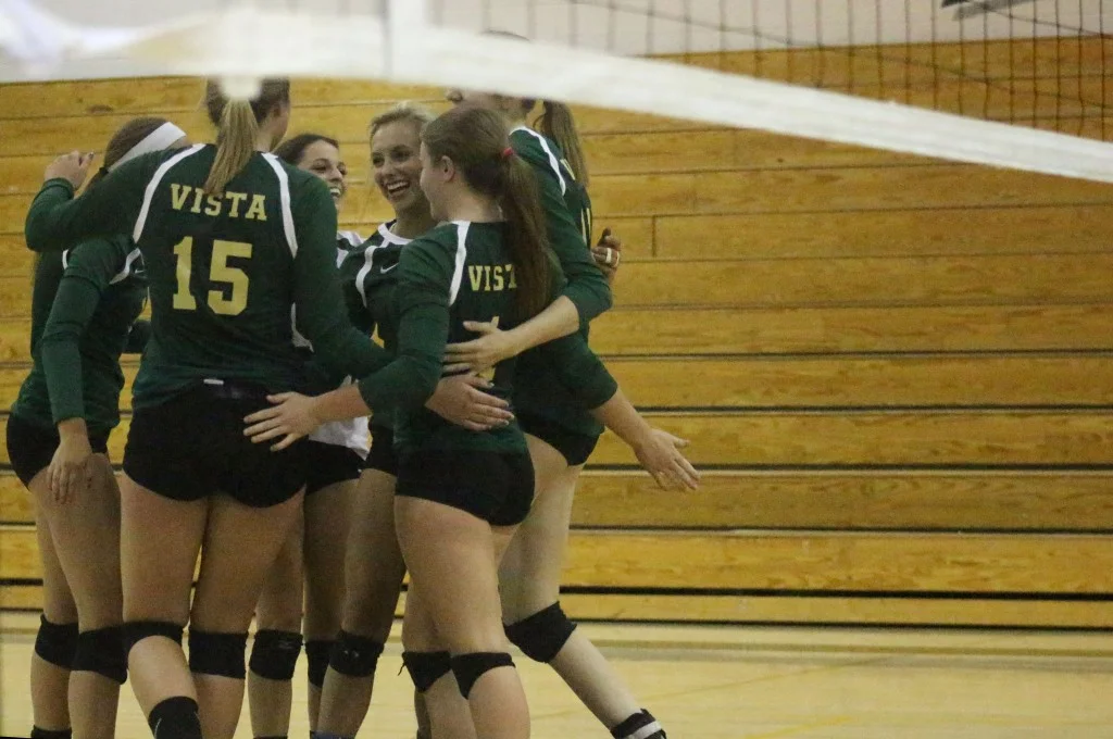 After serving an ace, the JV volleyball team congregates for a quick celebration.