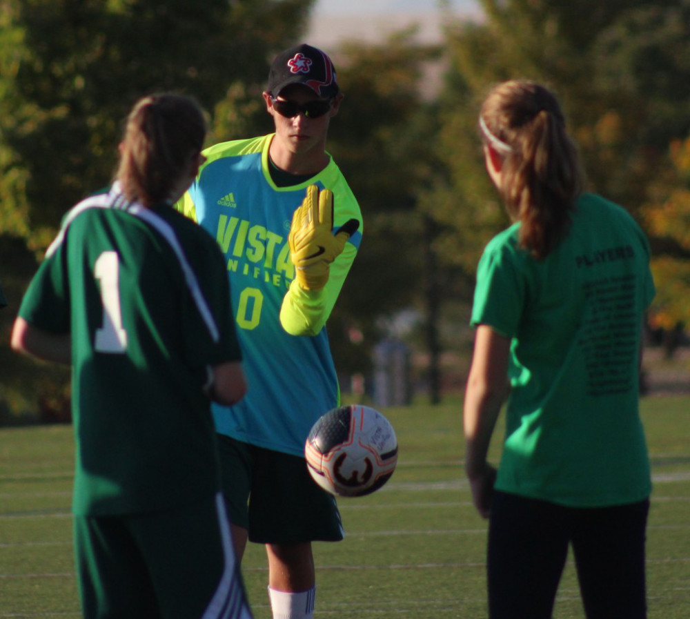 Senior Evan Kilcoyne throws the ball towards his teammate during a unified soccer game against ThunderRidge High School.