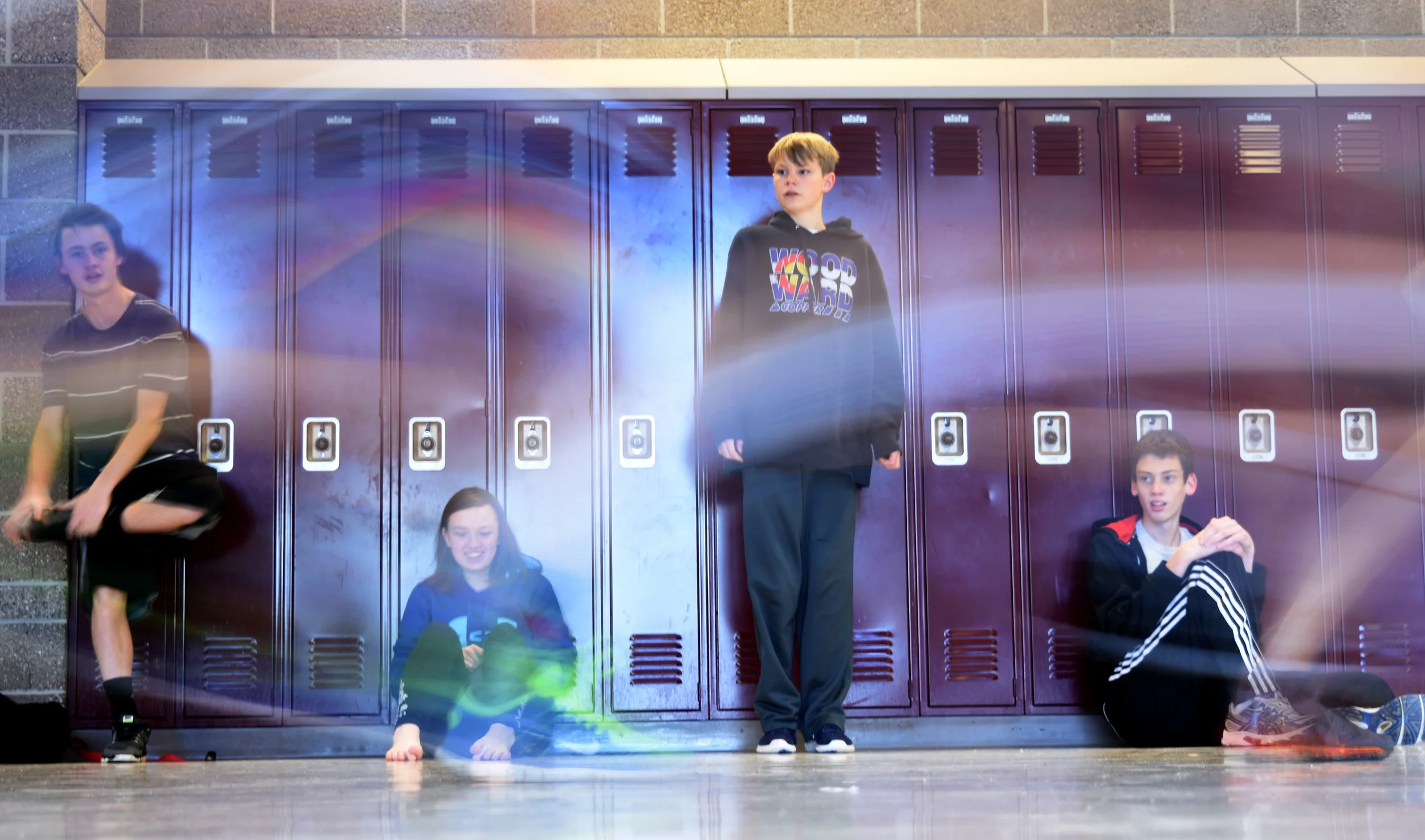 Members of Mountain Vista's ultimate frisbee team watch as their teammates run through the hallway.