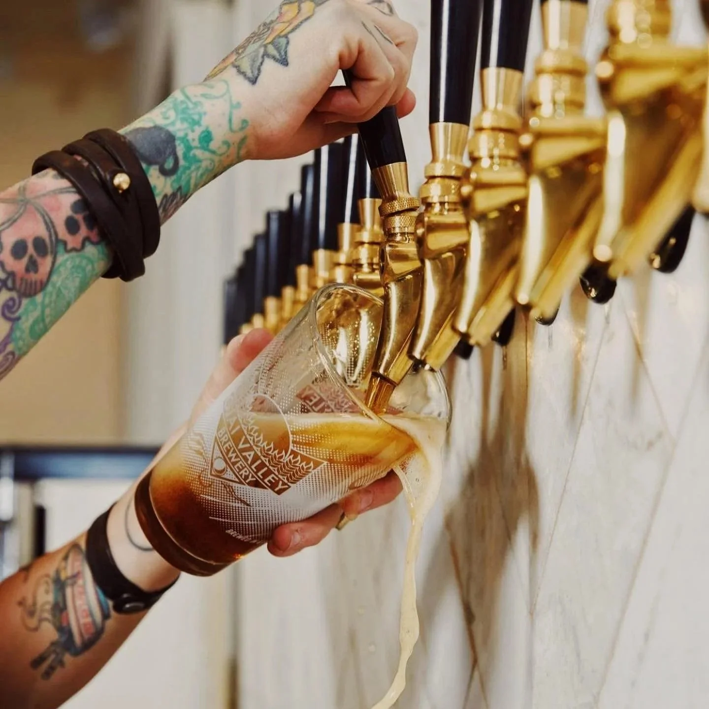 beer pouring in pint glass off beer taps