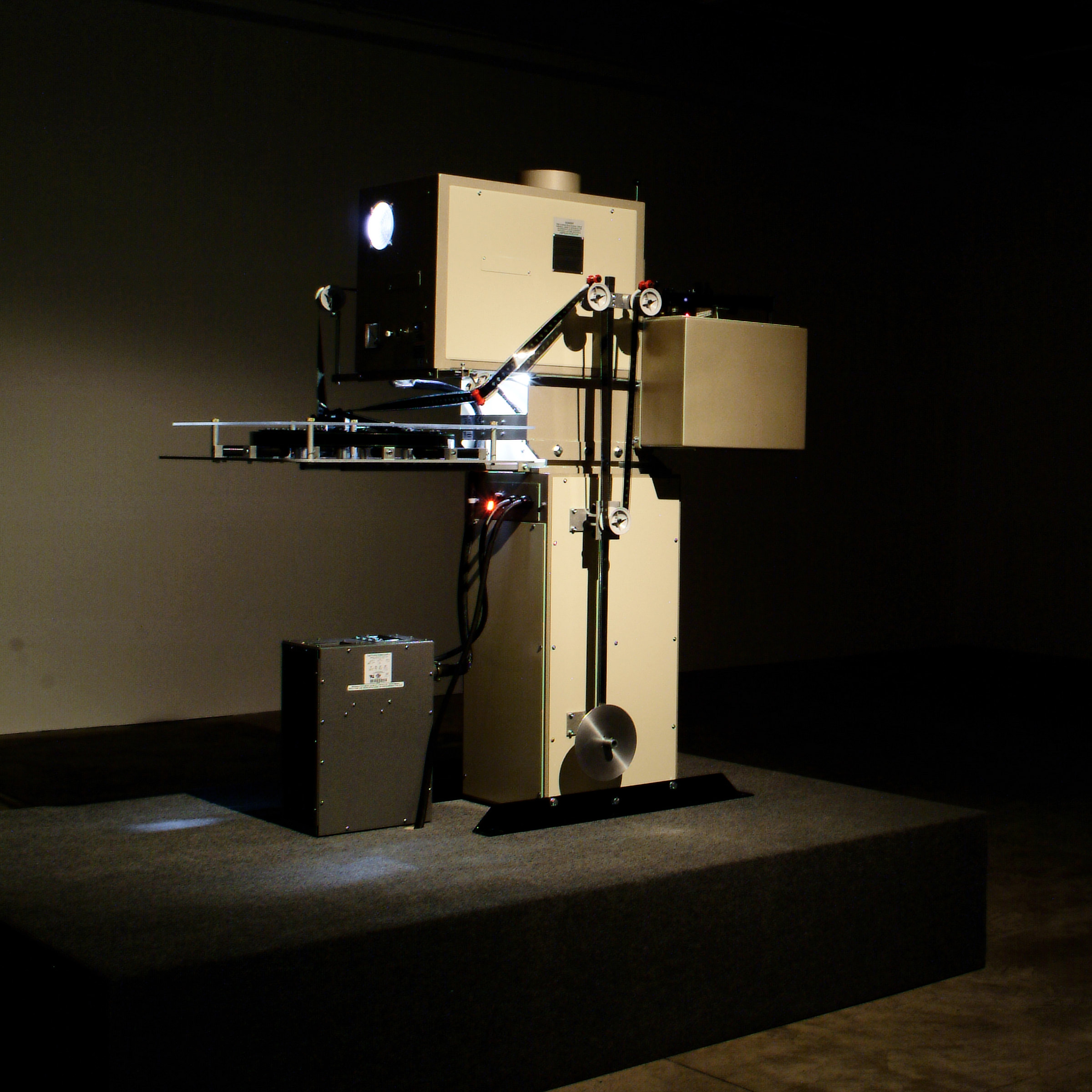 Industrial machine with a box-like structure, wires, and components on display platform