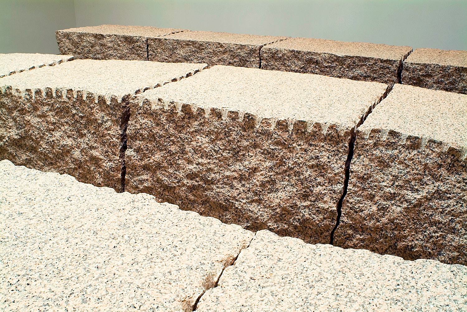 Close-up of rough-hewn granite blocks stacked in a staggered arrangement.