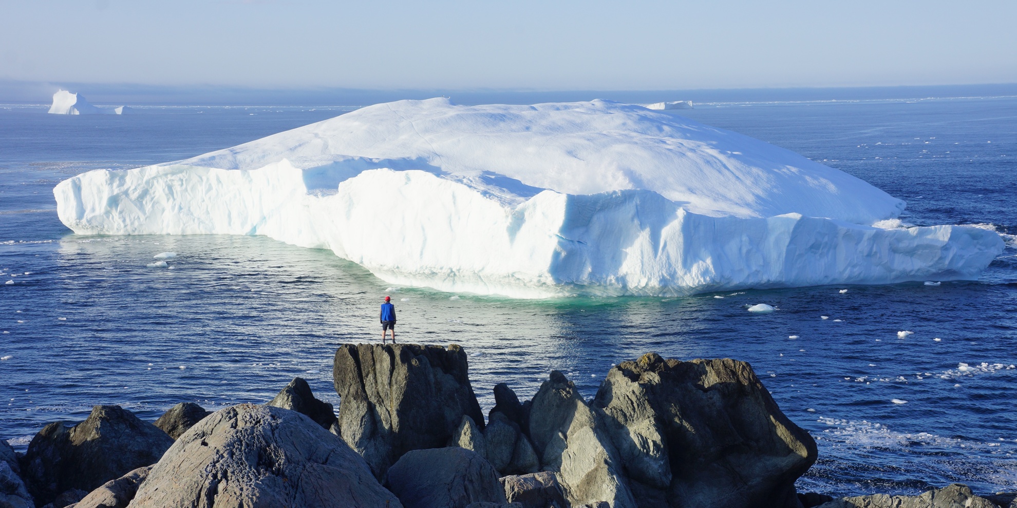 Iceberg and person in front of Quirpon Lighthouse Inn.JPG