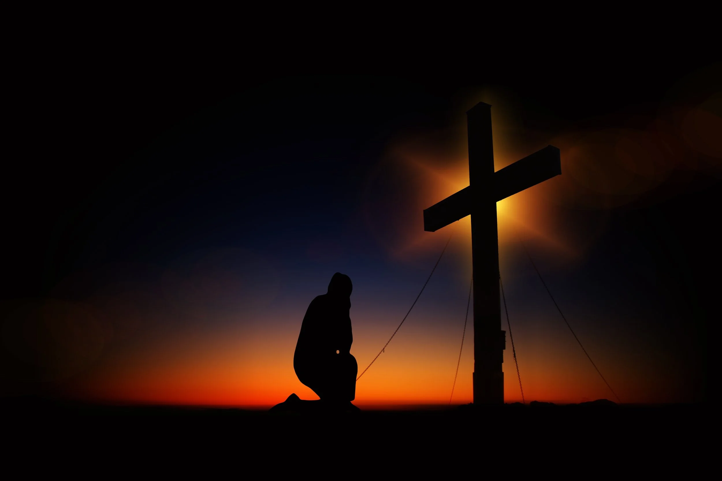 Kneeling praying before cross.jpg