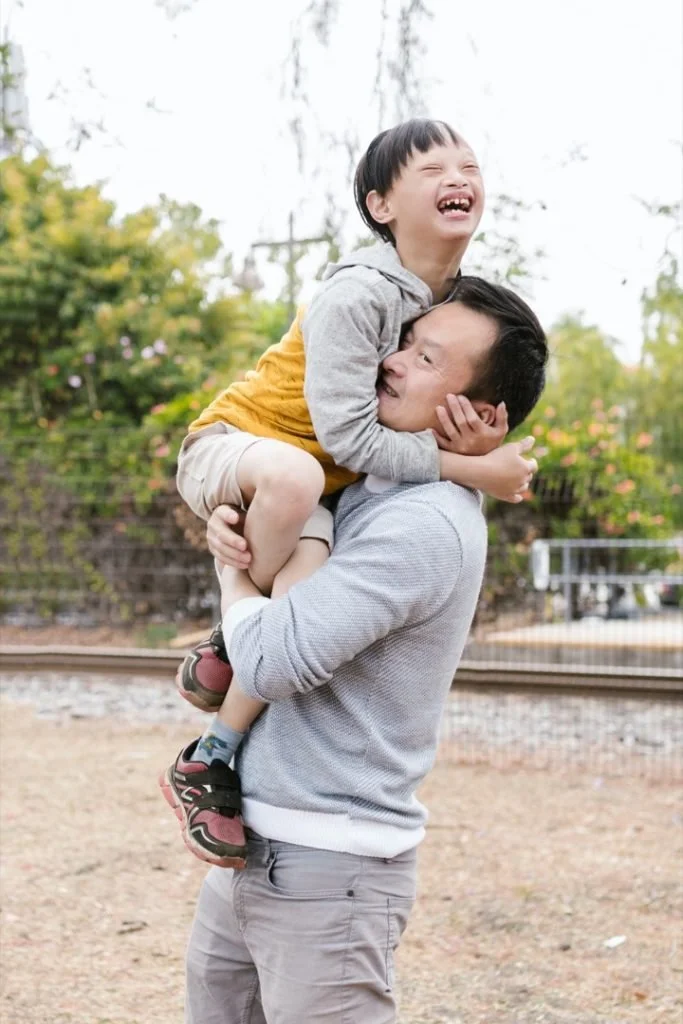 Image of a father lifting up his son who is smiling