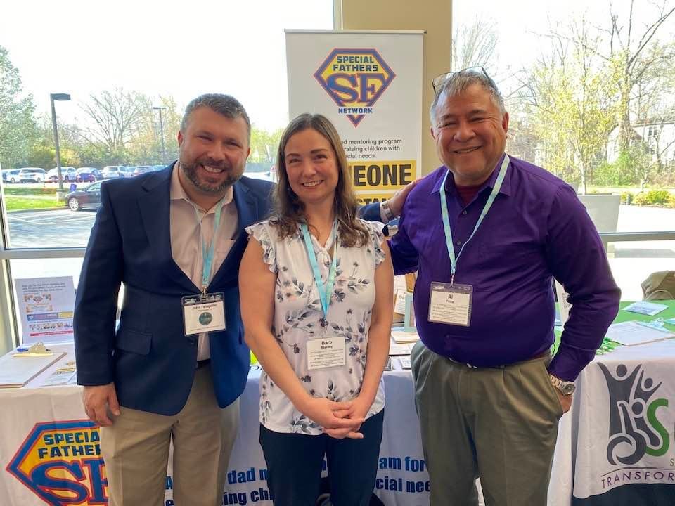 Image of 3 speakers in front of booths from the 2022 conference.