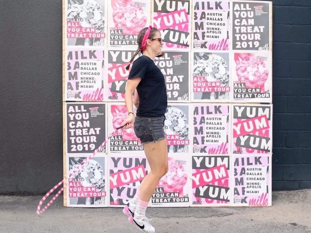 Poster covered step and repeat with woman jumping rope in front of it