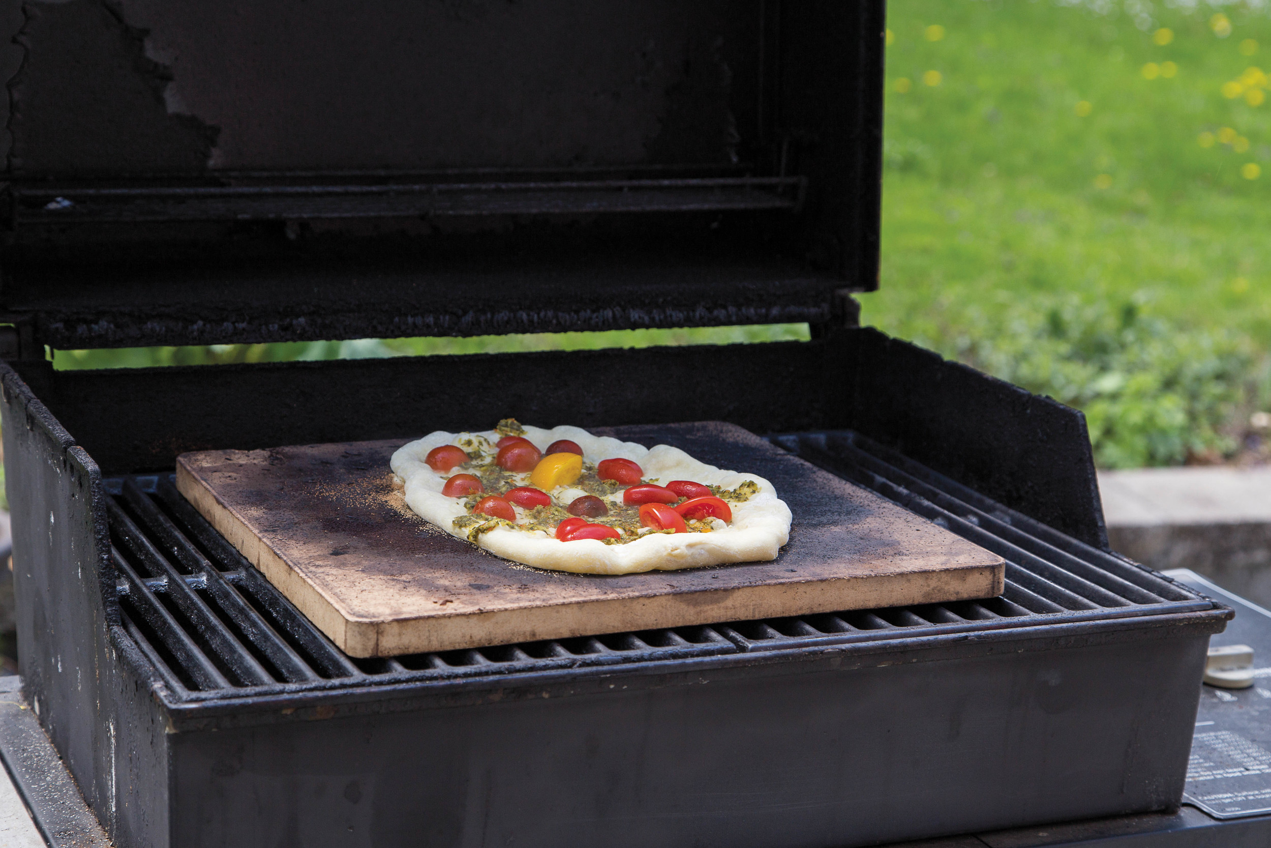 Love the idea of a wood-fired oven but your time or budget makes it unlikely that you can build your own? While the results aren’t identical––and the cooking method lacks some of the romance of an earthen structure––you can use a gas or charcoal grill to approximate the results of a cob oven. Build a fire in your grill: Aim for medium-low to medium-high, depending on what you’re cooking. Lay a baking stone on the grate and let it heat for at least half an hour. Follow your recipe, keeping the grill cover closed to approximate the oven effect of a woodfired oven.