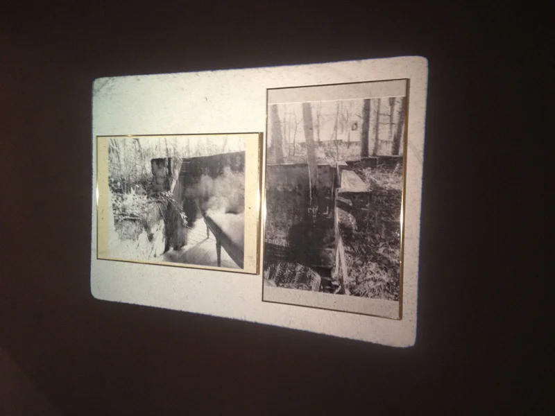 The projector on the opposite wall lights up two framed collages made up of images from fashion magazines and photos of the ruins of Conrad, Indiana. 