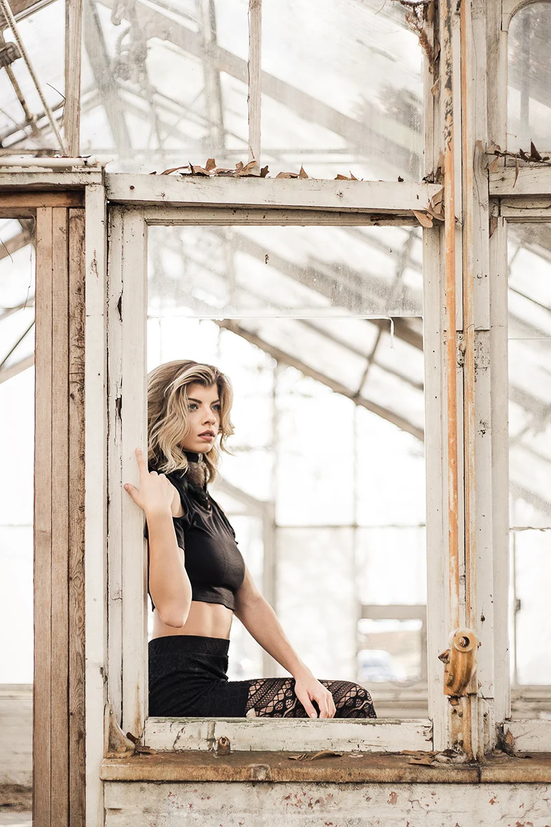Blonde-model-sitting-in-window-sill-Jenna-Schulz-in-abandoned-greenhouse-by-Atlanta-photographer-Chanel-French.jpg