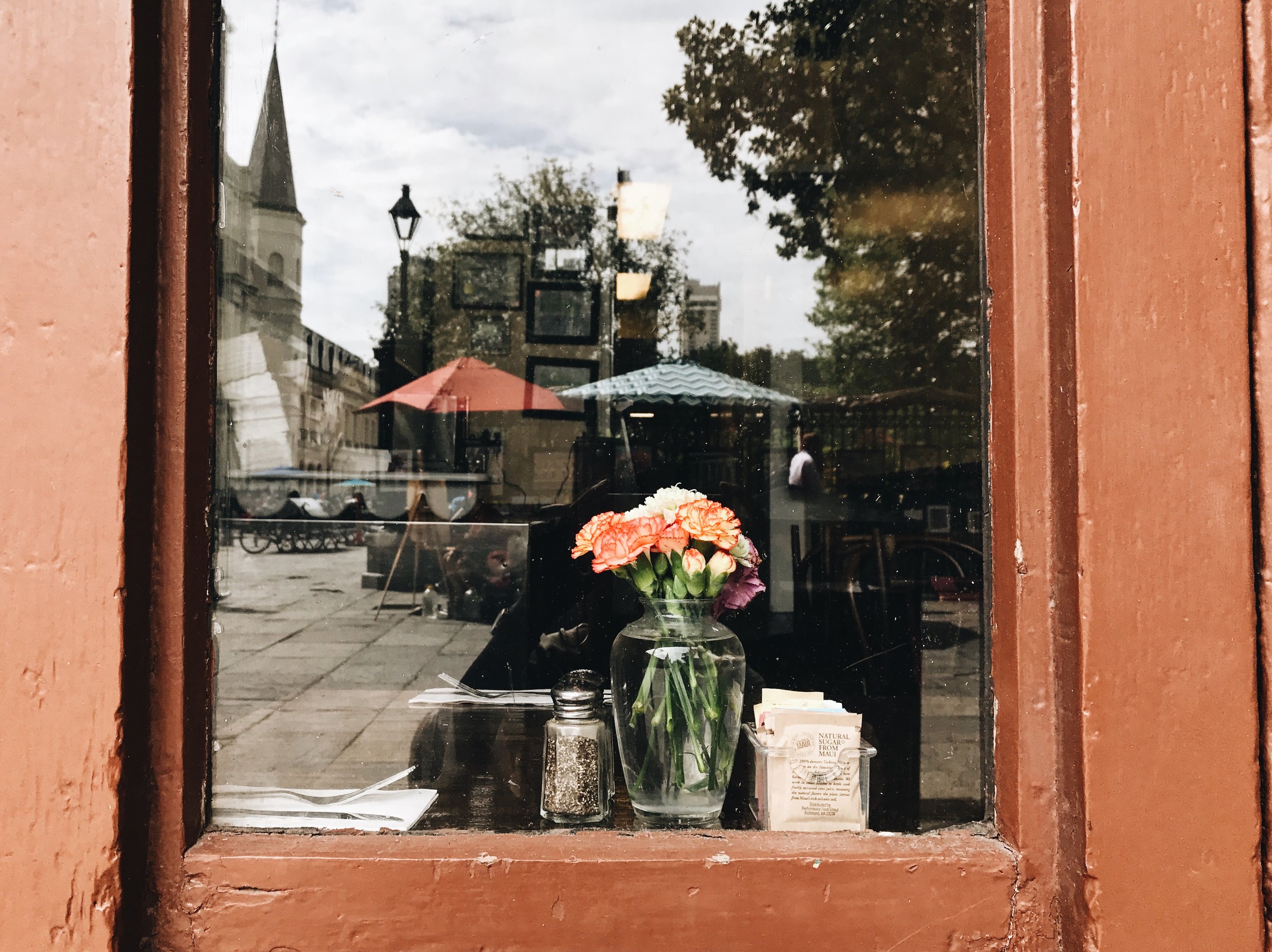 New-Orleans-street-photography-by-Atlanta-photographer-Chanel-French-flowers-in-cafe-window-French-quarter.jpg