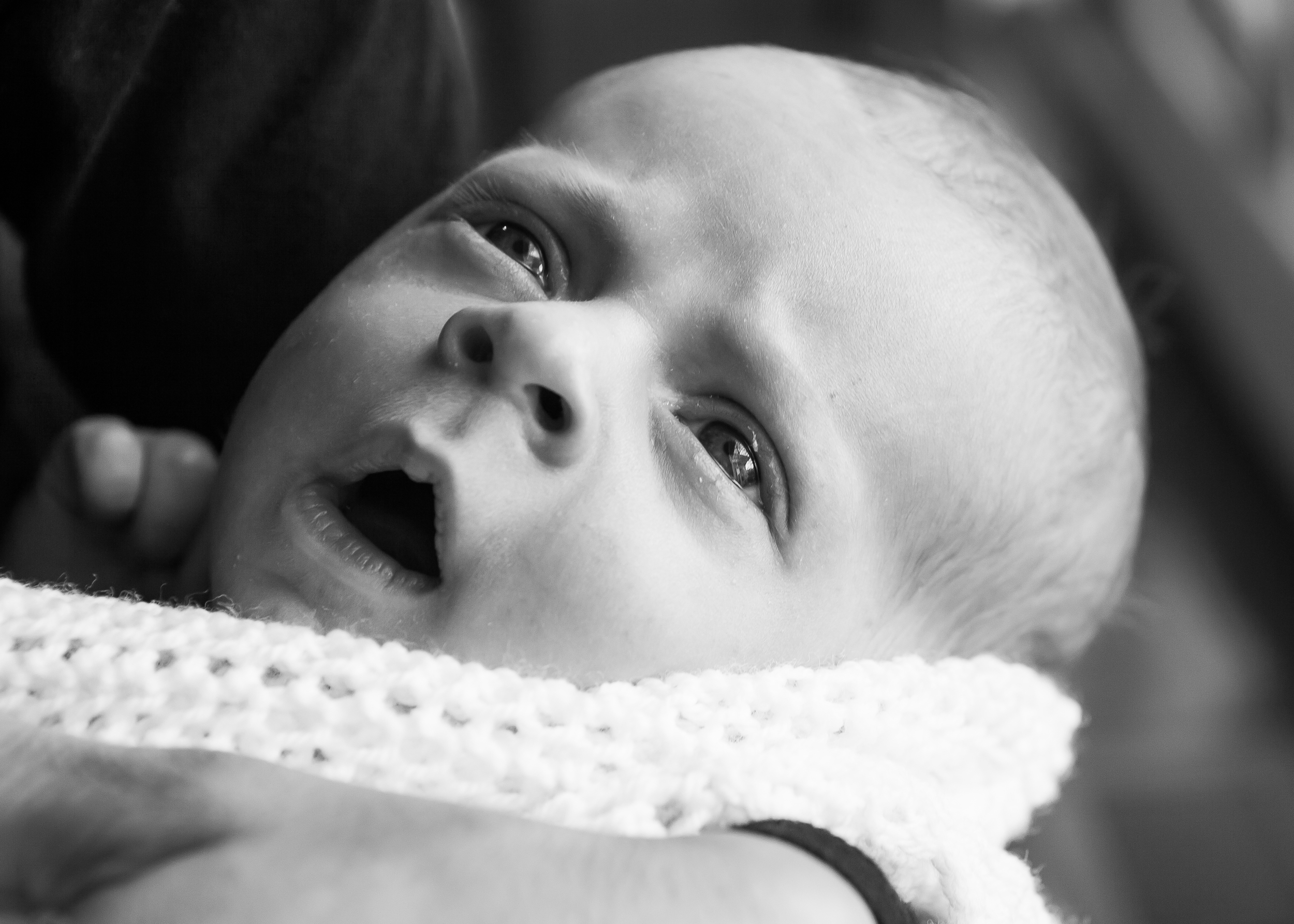 This newborn baby is in a 'quiet-alert' state, ready to interact with the world. His eyes are open with a bright look. His state is calm; he is relaxed, with minimal movement. He responds to stimuli (such as your face) with changes in his own facial expressions.