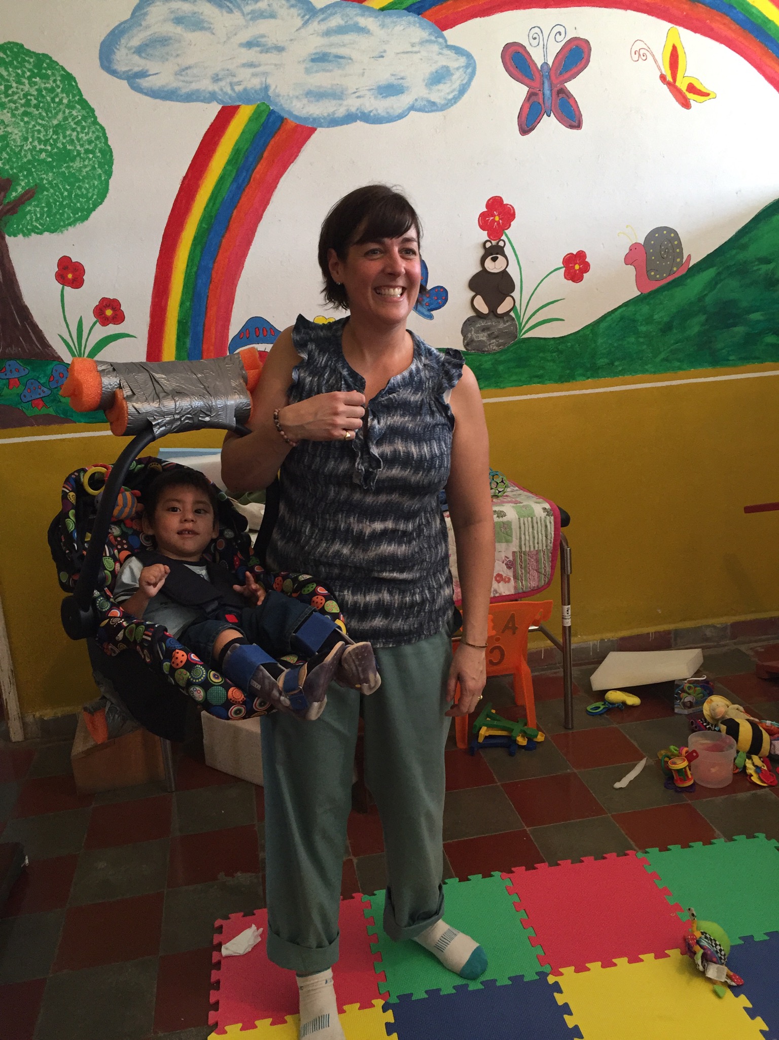 Ashely demonstrating to this patient's mother how she can also use his new seater to carry him.