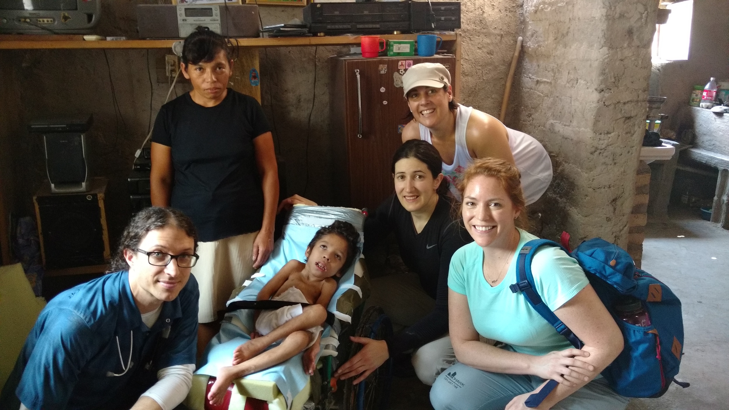 The team pictured with Moses in his new and improved wheelchair with his Mom.