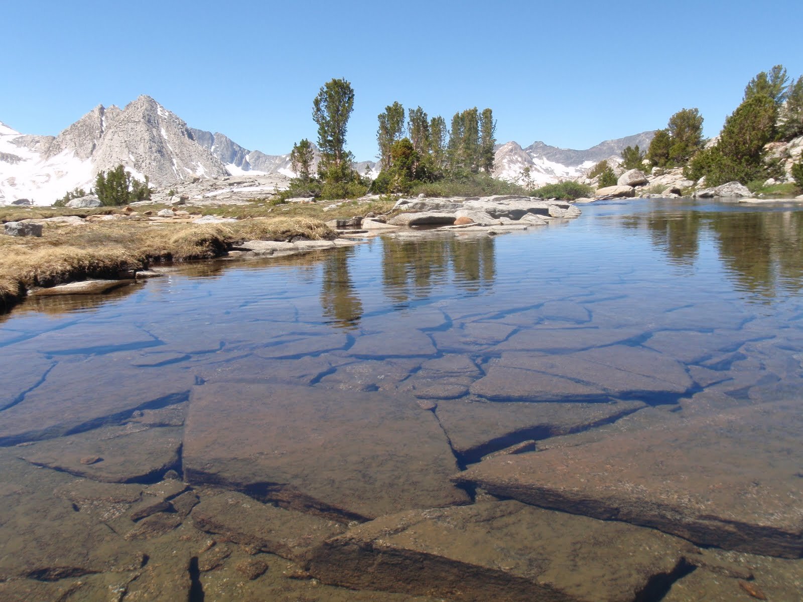 Day 7 Lower Darwin Bench large angular rocks under clear water with view of Hermit behind.JPG