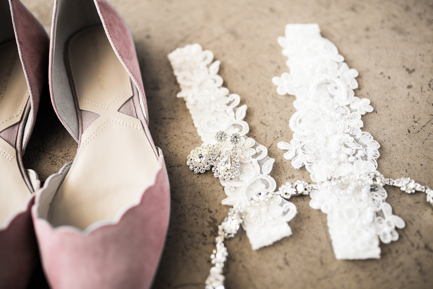 pink wedding flats next to wedding earring and garter details